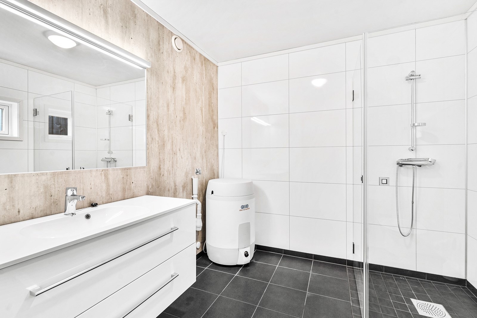 Badet er lyst og fint og har flislagt gulv og våtromsplater på vegger. Opplegg til vaskemaskin. Galleribilde