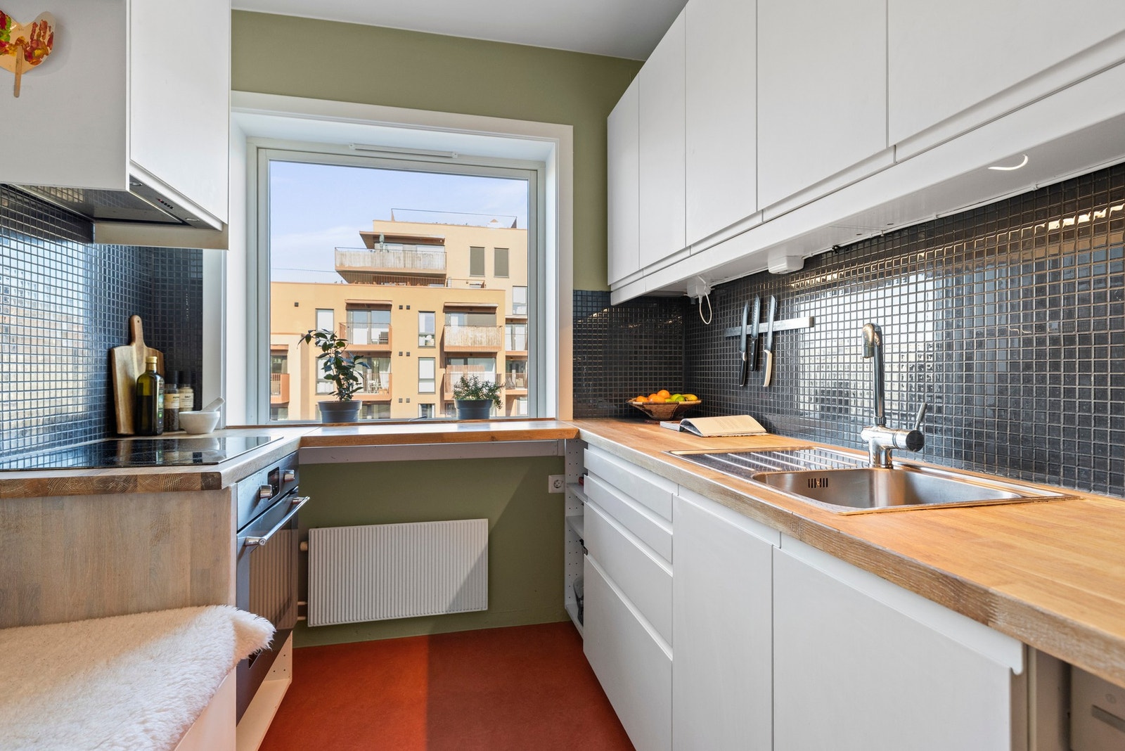 Kjøkken fra 2016 med glatte fronter, benkeplate i heltre og flislagt vegg
over kjøkkenbenk. Galleribilde