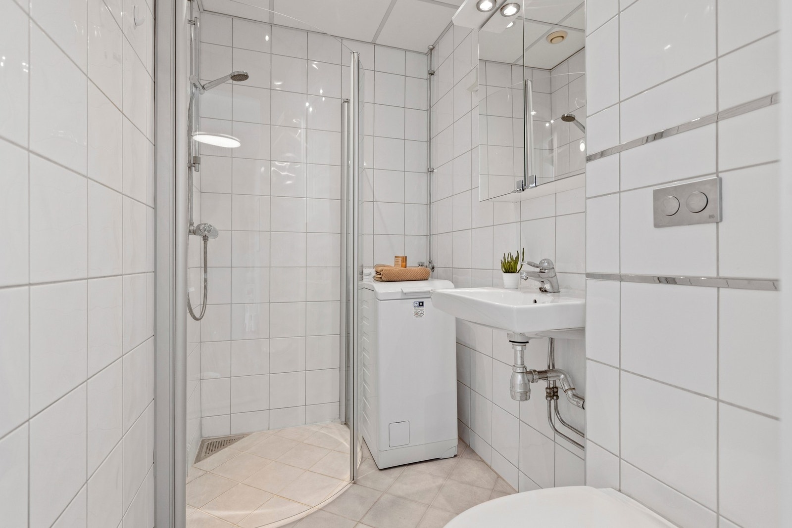 Pent, flislagt bad med opplegg for vaskemaskin. Galleribilde