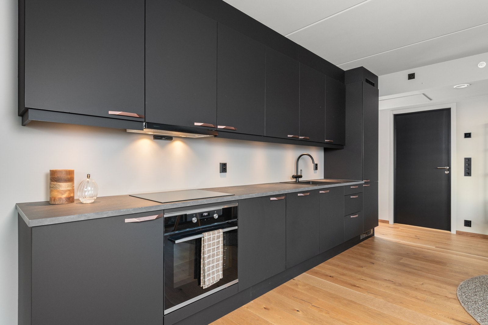 kjøkken med mørke fronter og god plass til oppbevaring og matlaging. Galleribilde