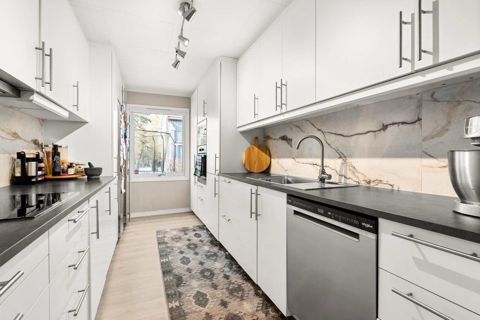 Kjøkken med glatte fronter og benkeplate i laminat med nedfelt stålkum Galleribilde