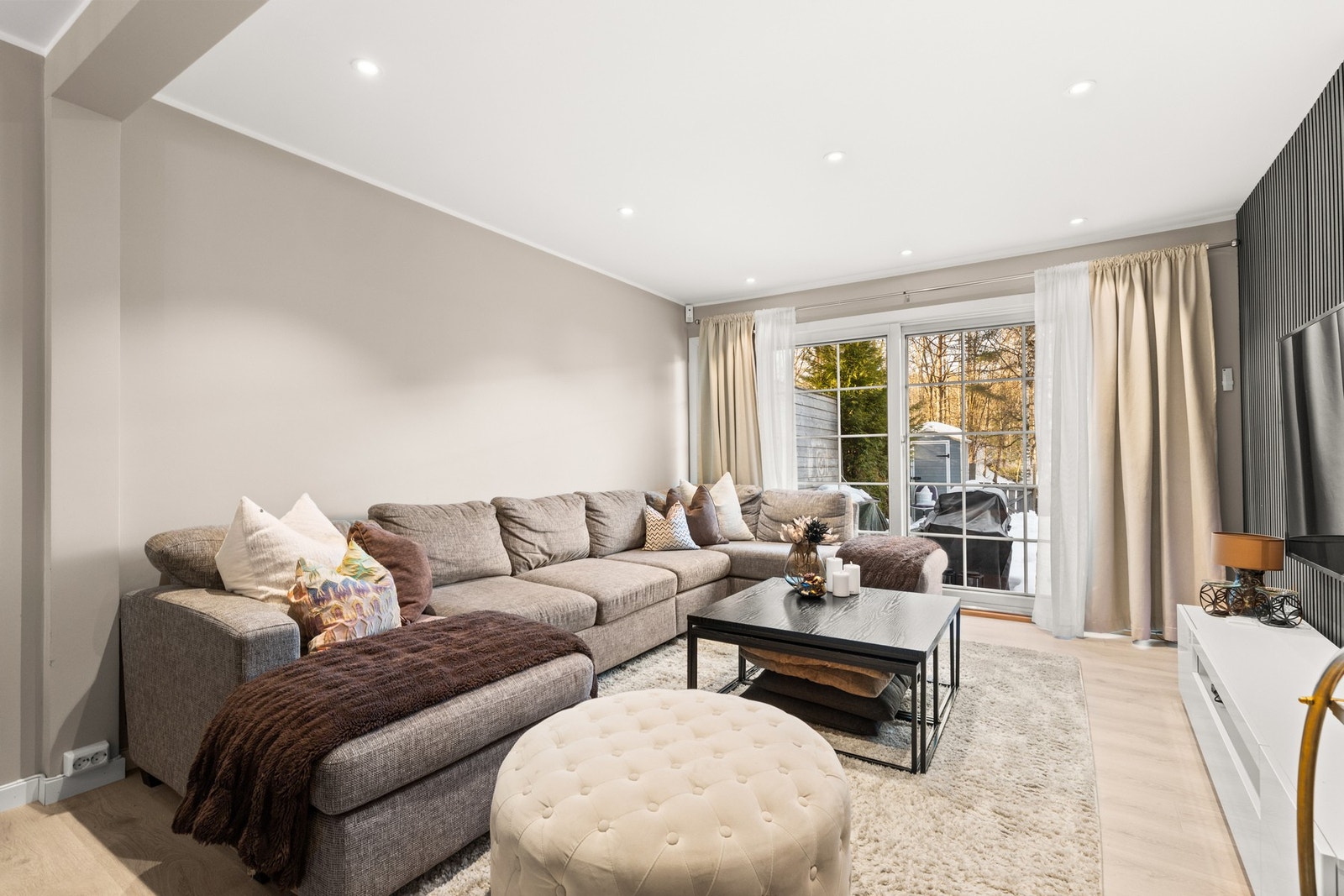 Rommet er holdt i delikate fargetoner med laminat på gulv og lysmalte vegger Galleribilde