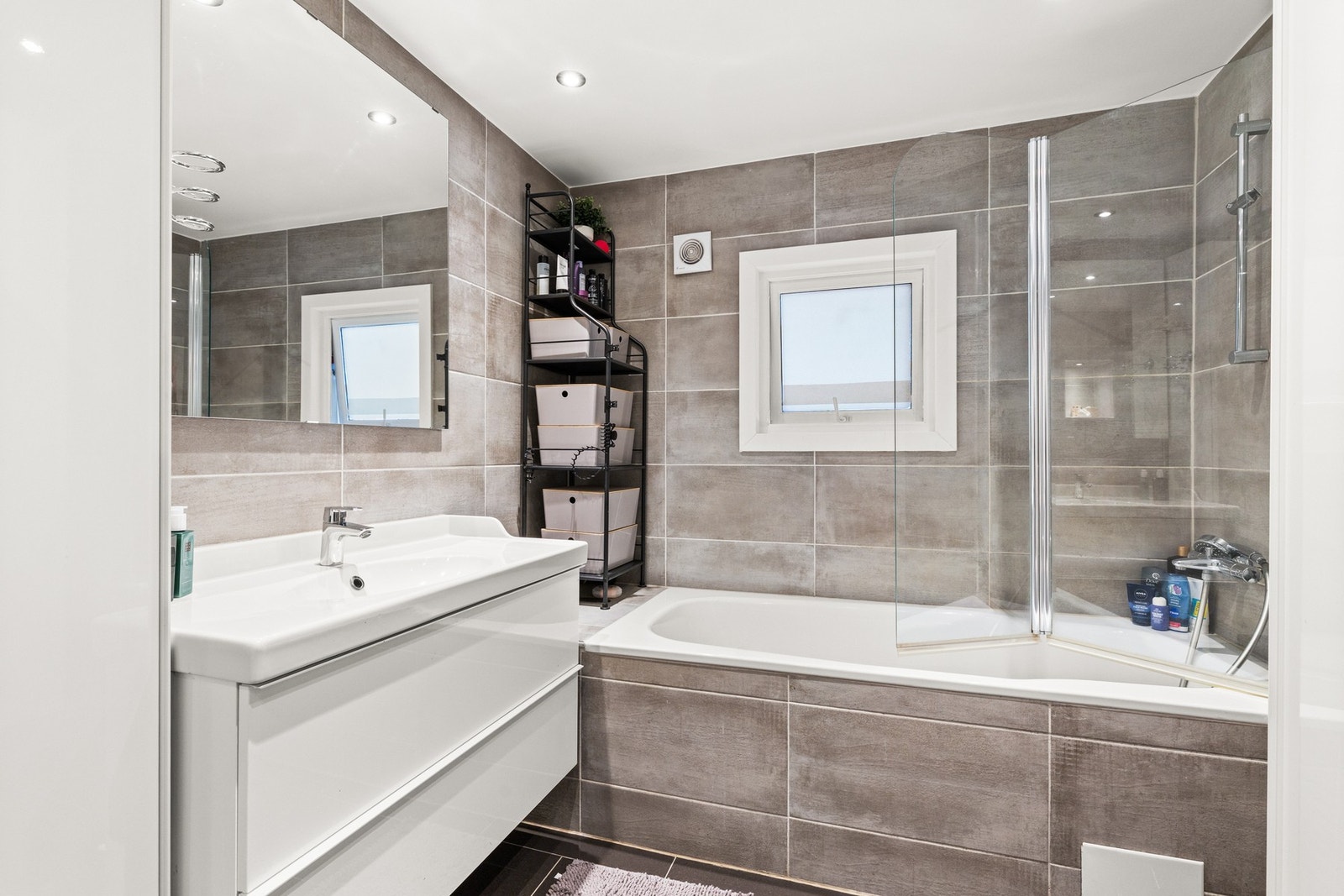 Badet er utstyrt med ettgreps kran, vegghengt toalett med skjult sisterne og svingbare dusjvegger av glass Galleribilde