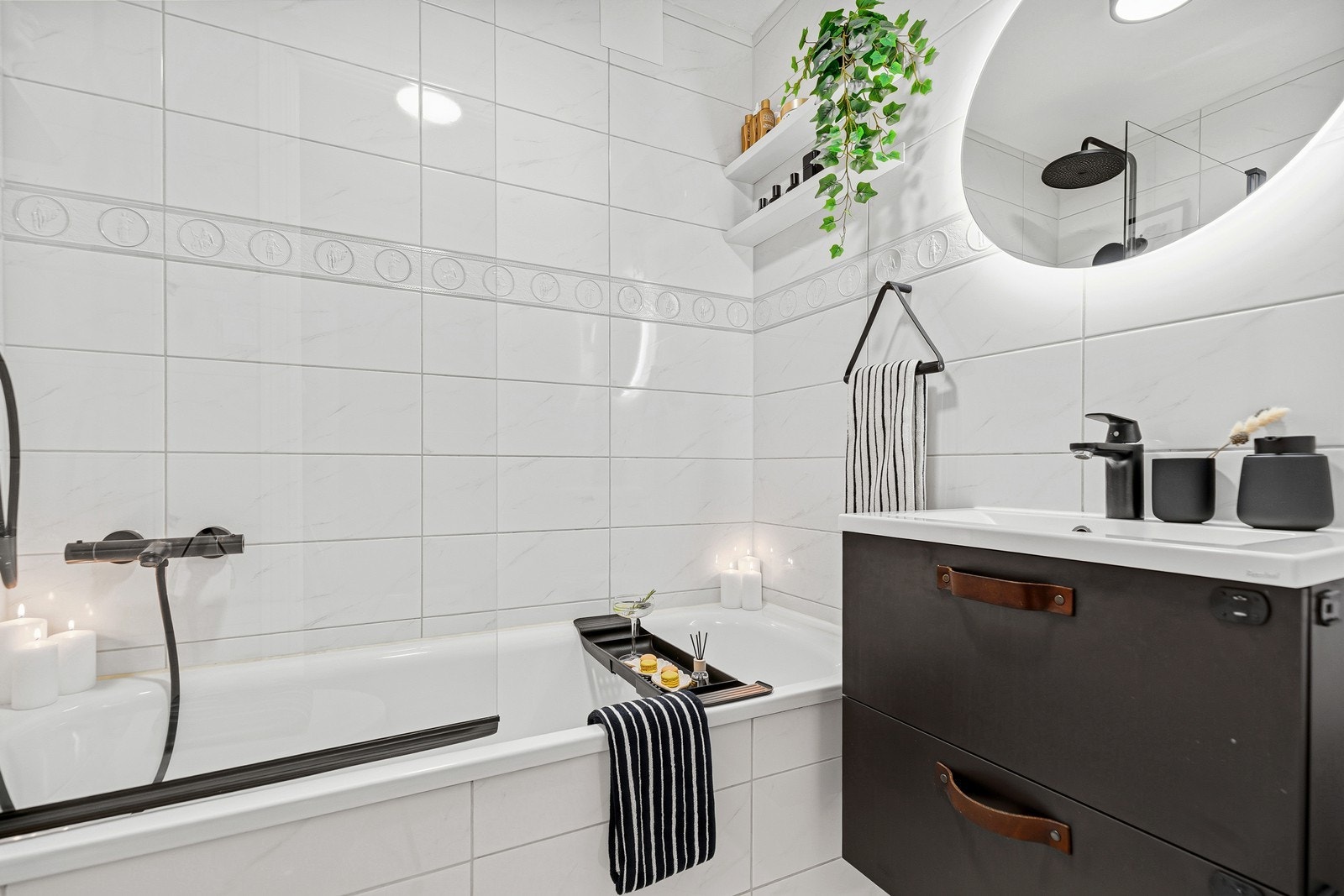 Baderomsinnredning består av badekar, toalett, servant og vegghengt speil med belysning Galleribilde