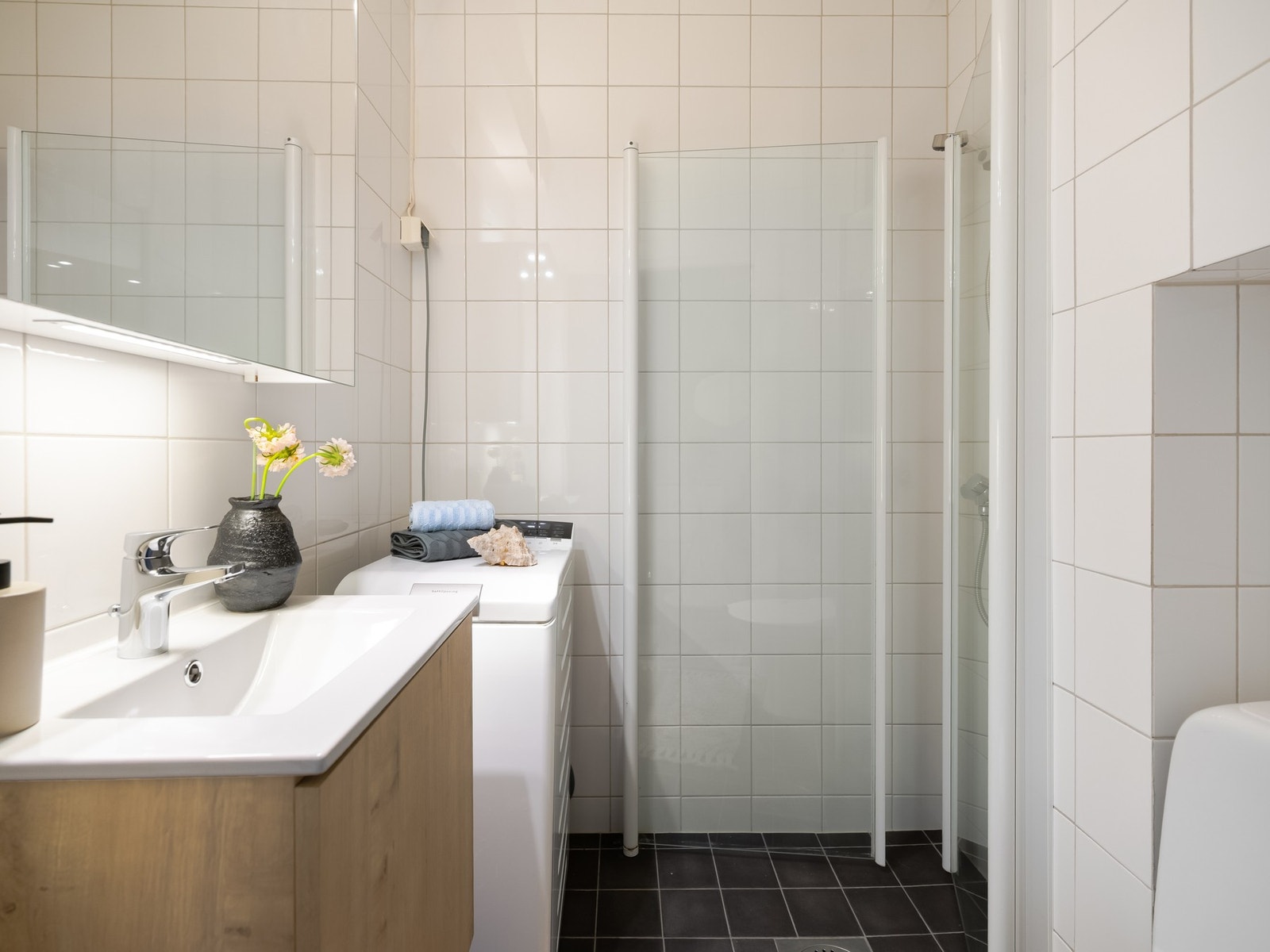 Badet er innredet med toalett, servantskap (nytt i 2026), speilskap på vegg og dusjsone med innfellbare dusjdører. Galleribilde