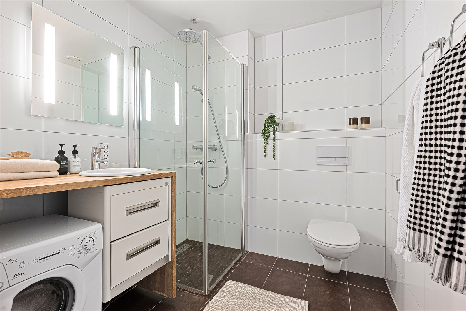 Lyst flislagt baderom med varmekabler i gulv og downlights i himling. Galleribilde