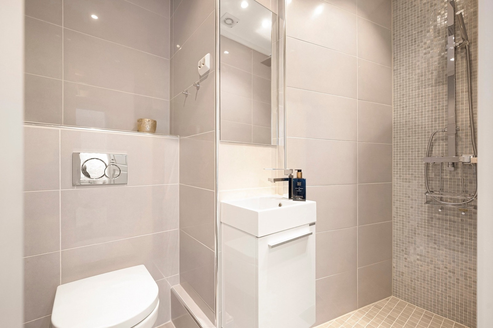 Badet er innredet med servantseksjon med skap for praktisk oppbevaring, dusjnisje og vegghengt toalett. Galleribilde