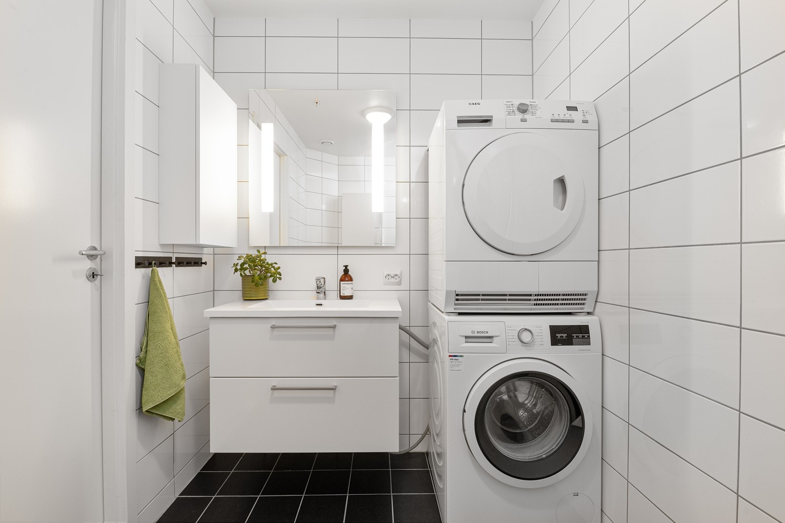 Innredning med nedfelt servant og opplegg for vaskemaskin og tørketrommel. Galleribilde