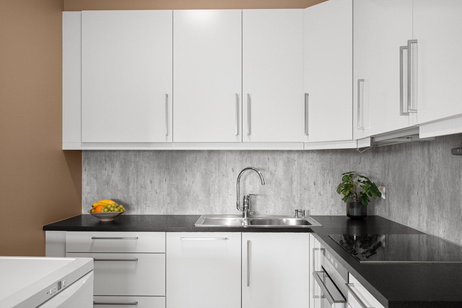 Innredet med glatte fronter, benkeplate i laminat og delvis integrerte hvitevarer. Galleribilde