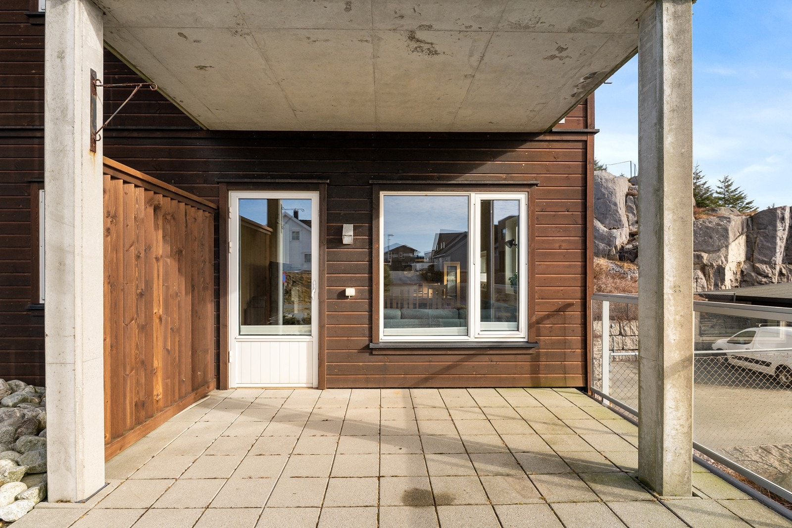 Terrassen er utført i betong med steinheller og har et stilrent glassrekkverk. Galleribilde