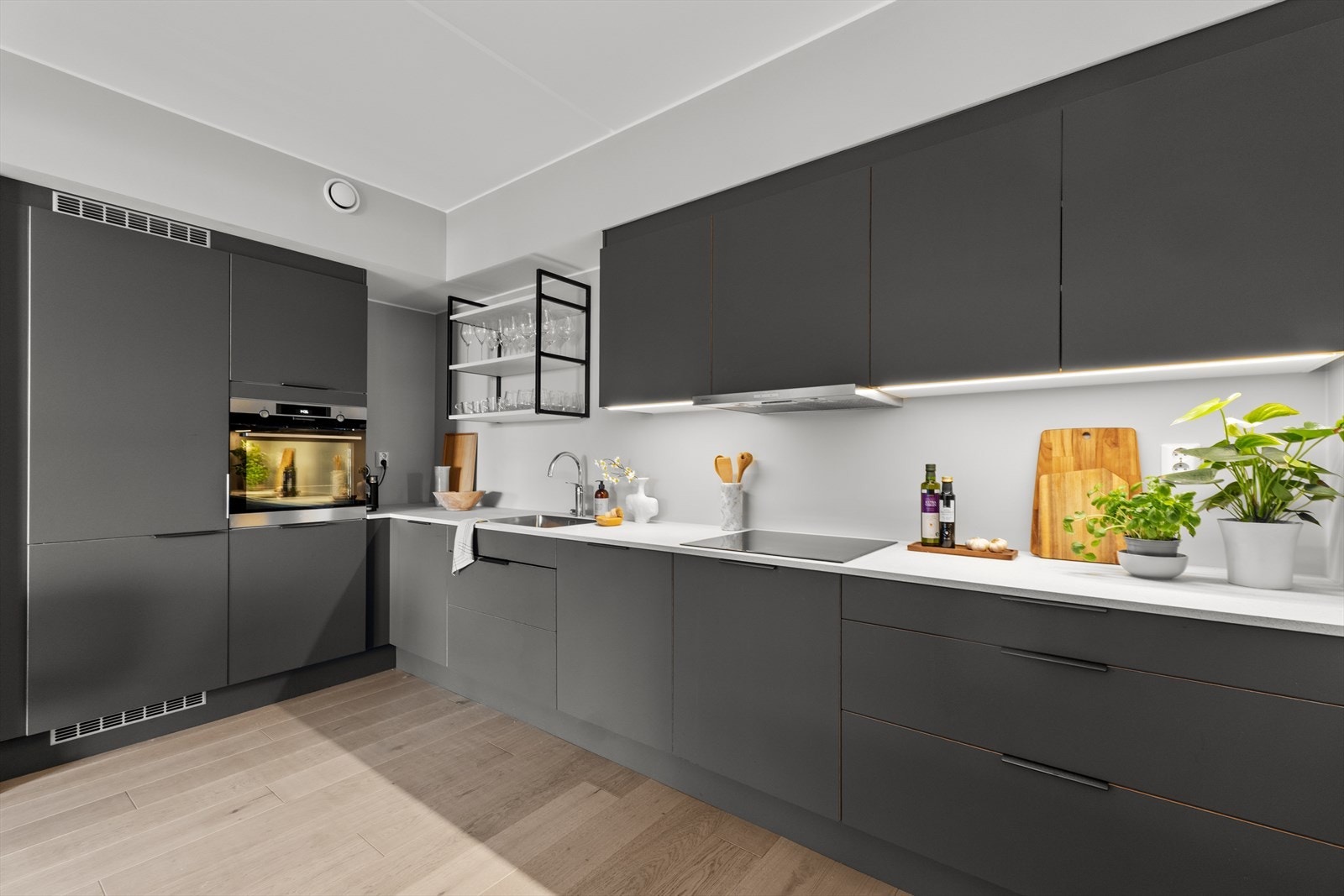 Pent og moderne HTH kjøkkeninnredning fra 2023 med slette fronter og laminat benkeplate. Galleribilde