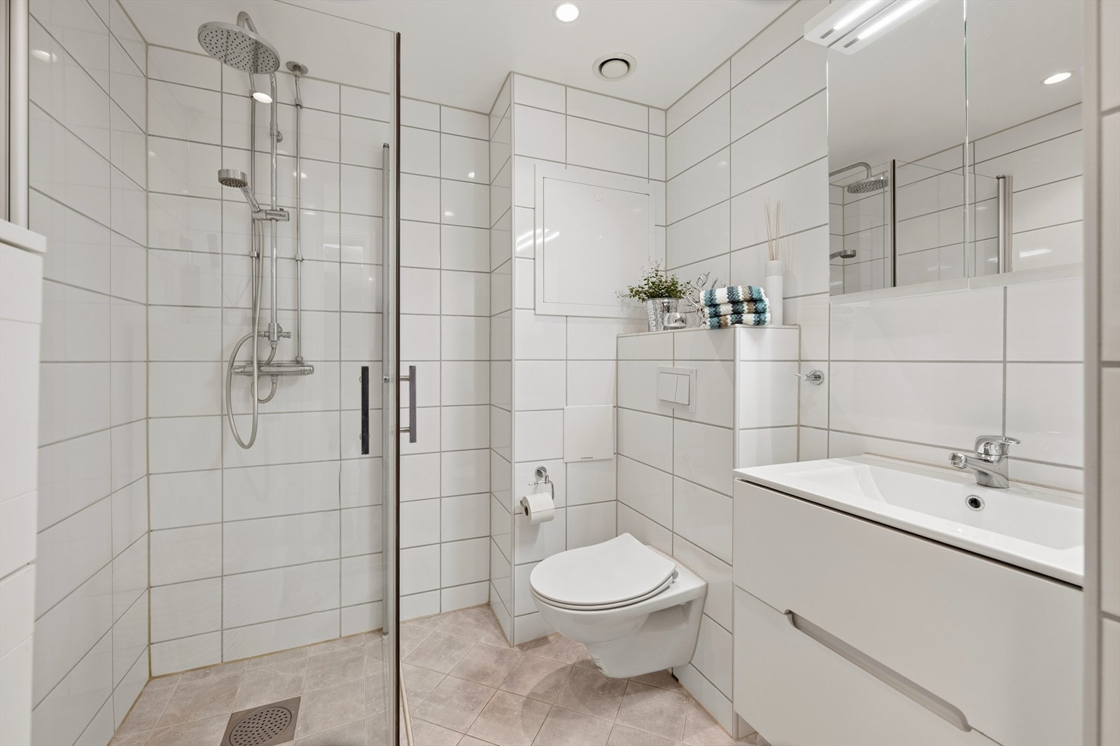 Rommet har innredning med nedfelt servant, veggmontert toalett, dusjvegger og opplegg for vaskemaskin. Galleribilde