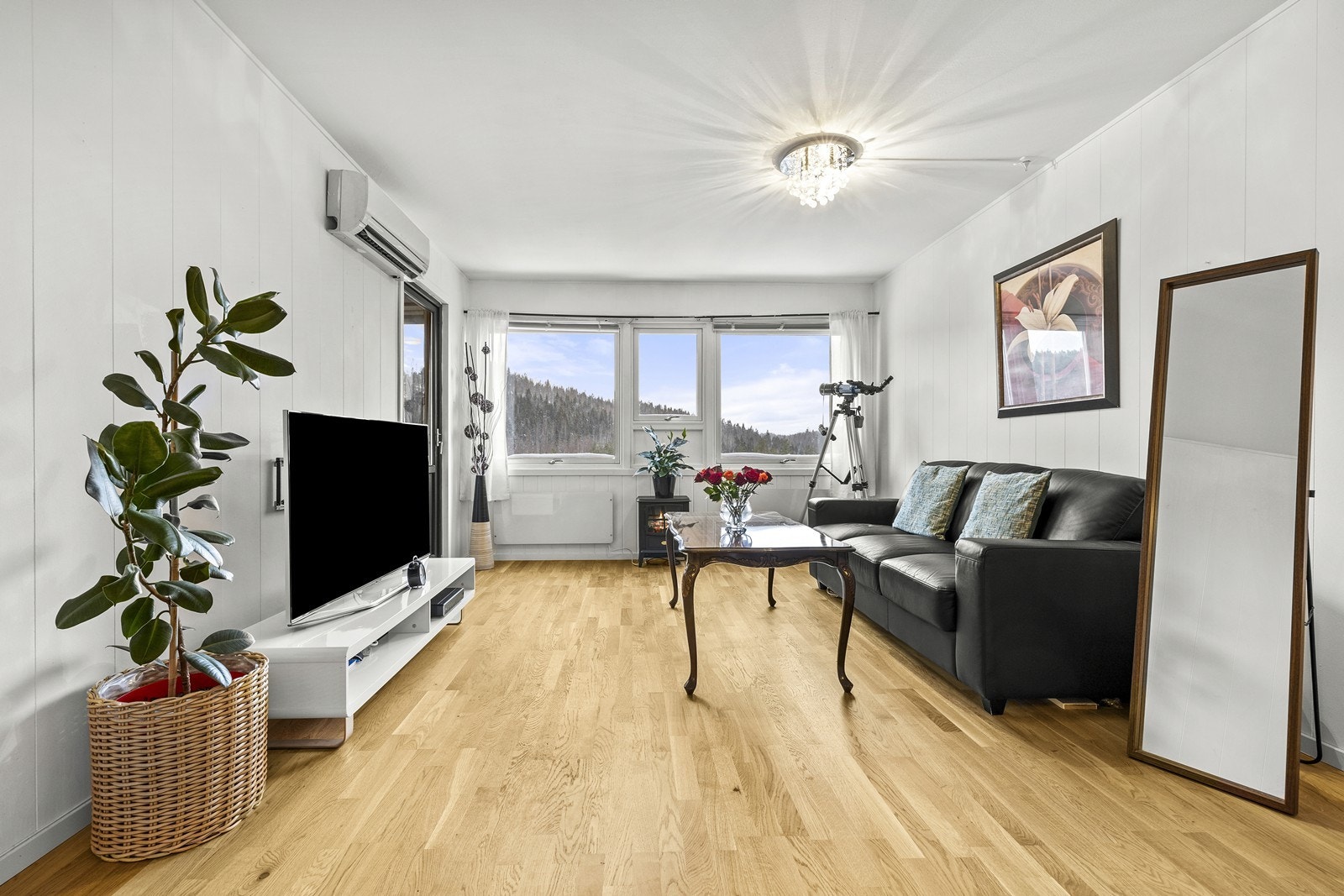 Store vindusflater gir rikelig med naturlig lys, og parkettgulvet i stuen ble skiftet i 2023. Galleribilde