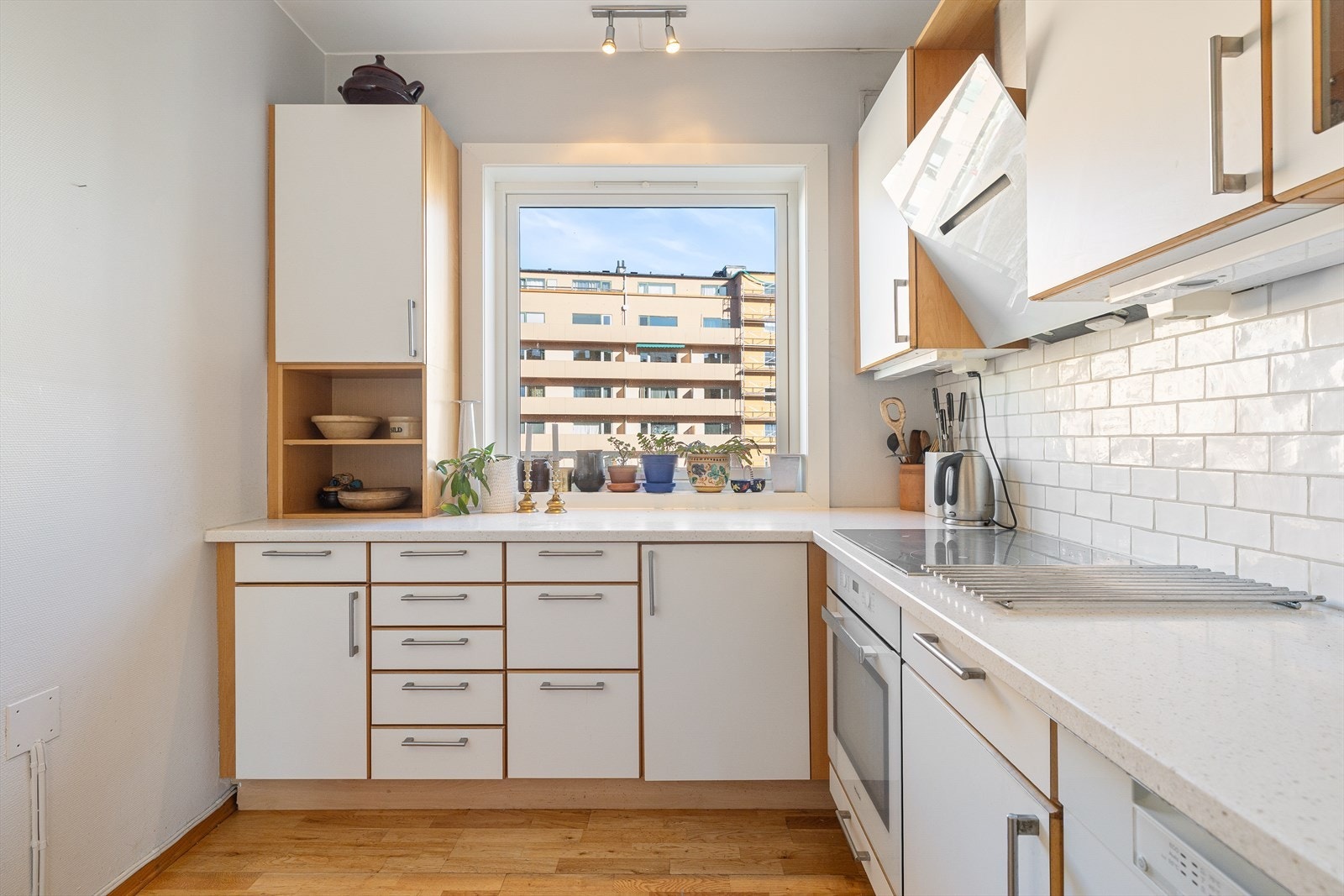 Kjøkkeninnredningen har glatte fronter, fliser på vegg over kjøkkenbenk og benkeplate i kompositt (fra 2015). Galleribilde