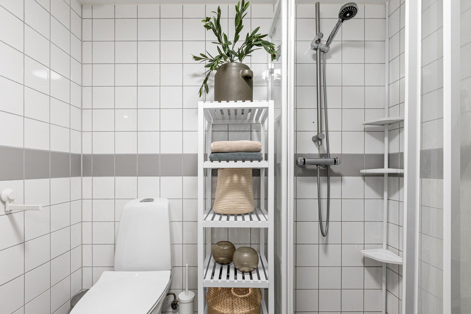 idere inneholder baderommet servantskap med glatte fronter, heldekkende servant, innmurt speil, lysarmatur på vegg over servant, gulvmontert klosett, samt dusjhjørne med skyvedører, sluk og termostatstyrt blandebatteri. Galleribilde