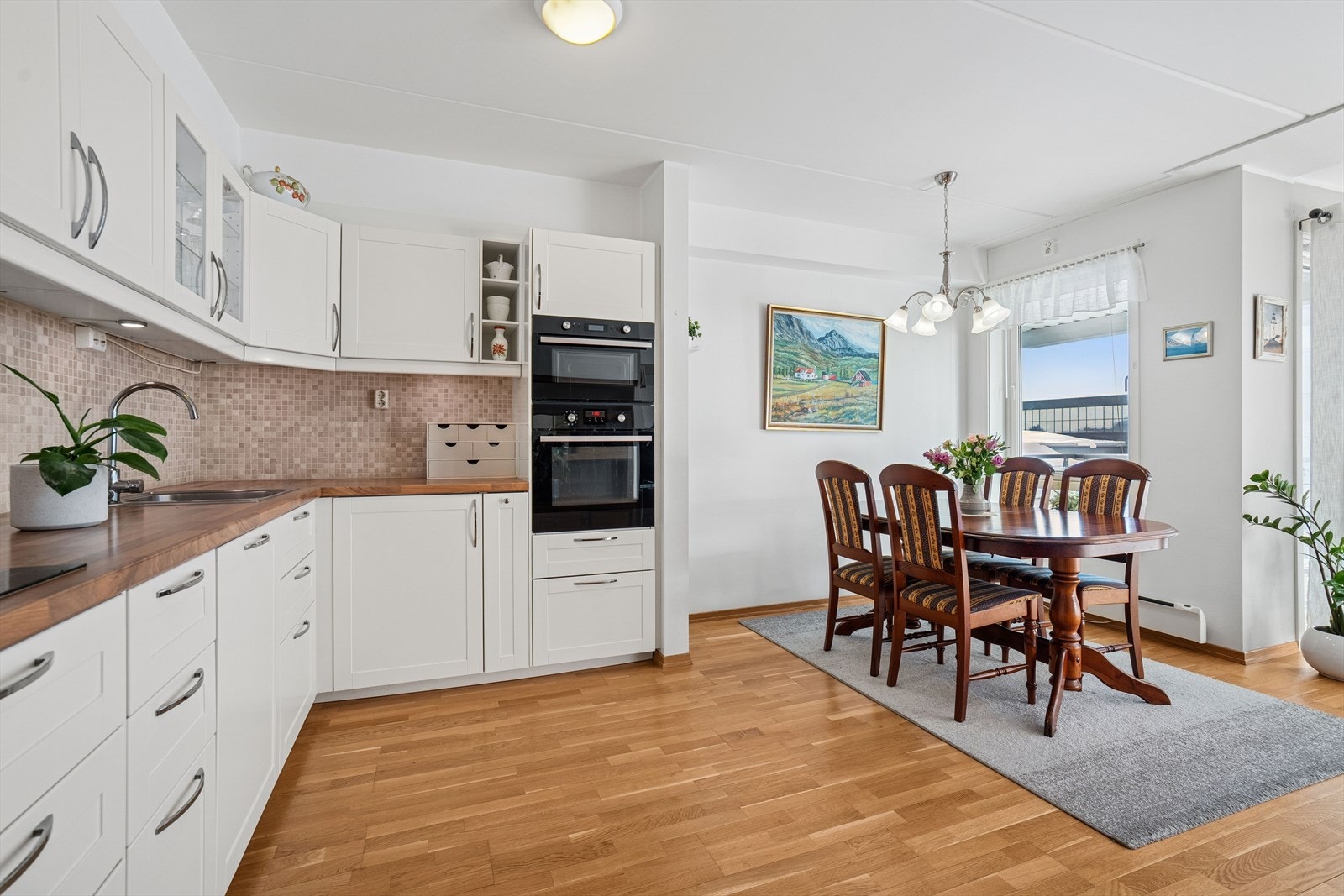 Kjøkkenet er utstyrt med hvitevarer som kjøl-/fryseskap, oppvaskmaskin, induksjonstopp, mikrobølgeovn og stekeovn. Galleribilde