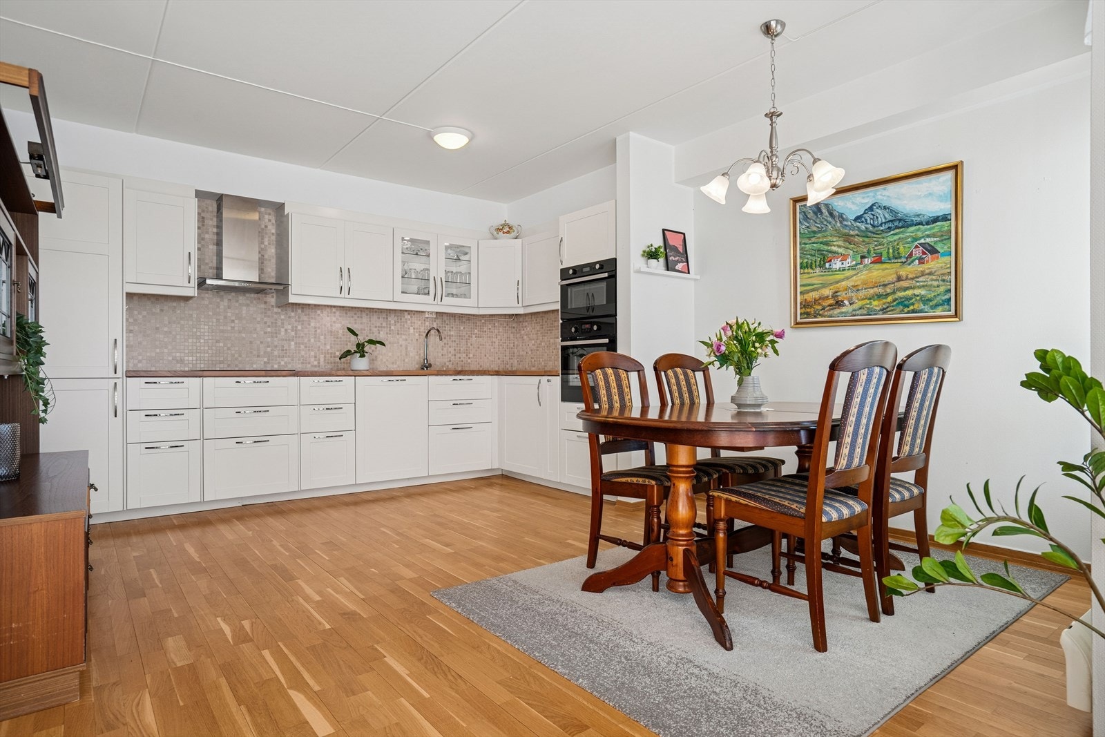 Kjøkkenet er lyst med hvite, glatte fronter som gir et stilrent og tidløst uttrykk Galleribilde