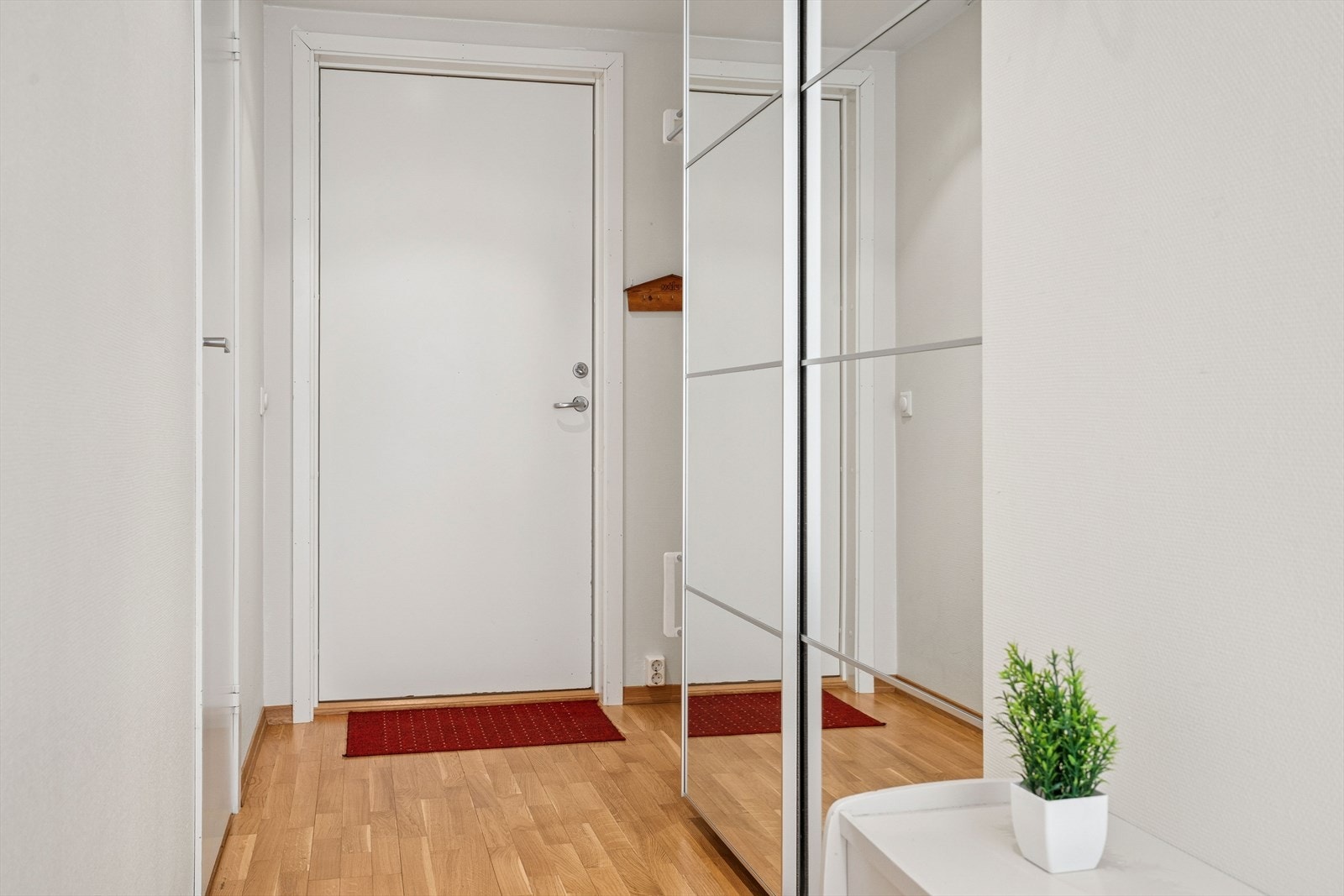 Her ønskes man velkommen inn i en praktisk entré med skyvedørsgarderobe og plass til å henge fra seg yttertøyet Galleribilde