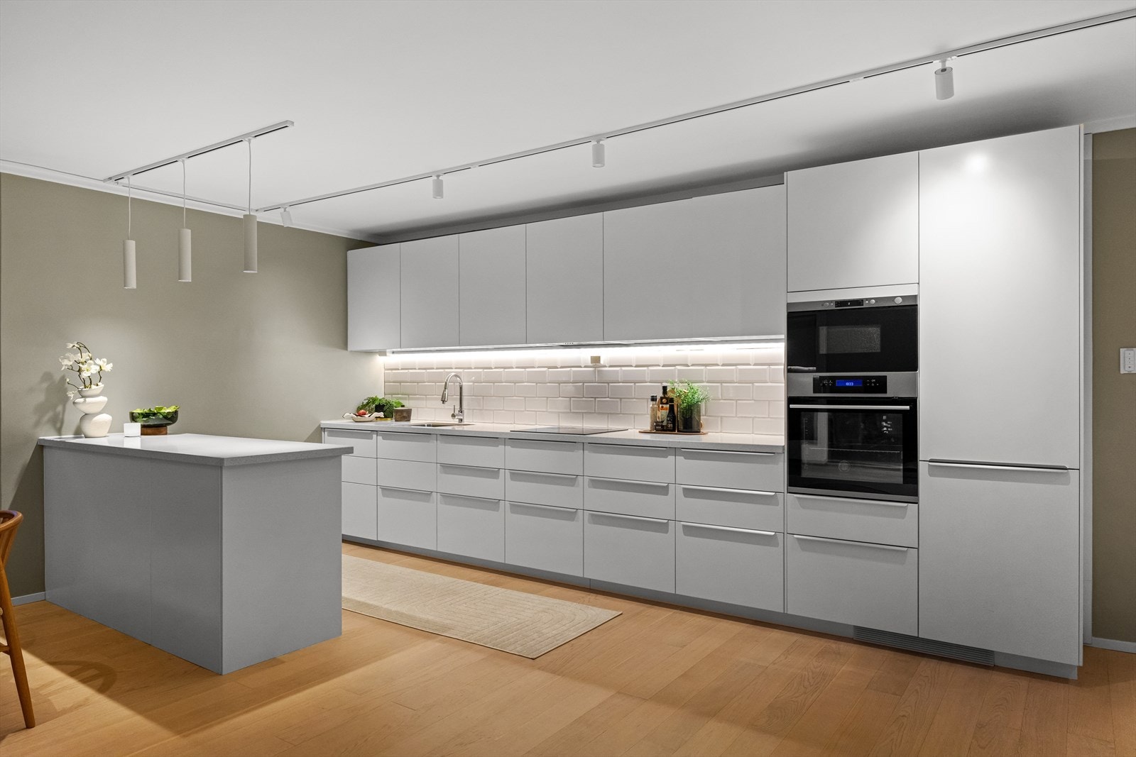 Kjøkkeninnredning fra 2017 med glatte fronter og flislagt vegg over benkeskap. Galleribilde