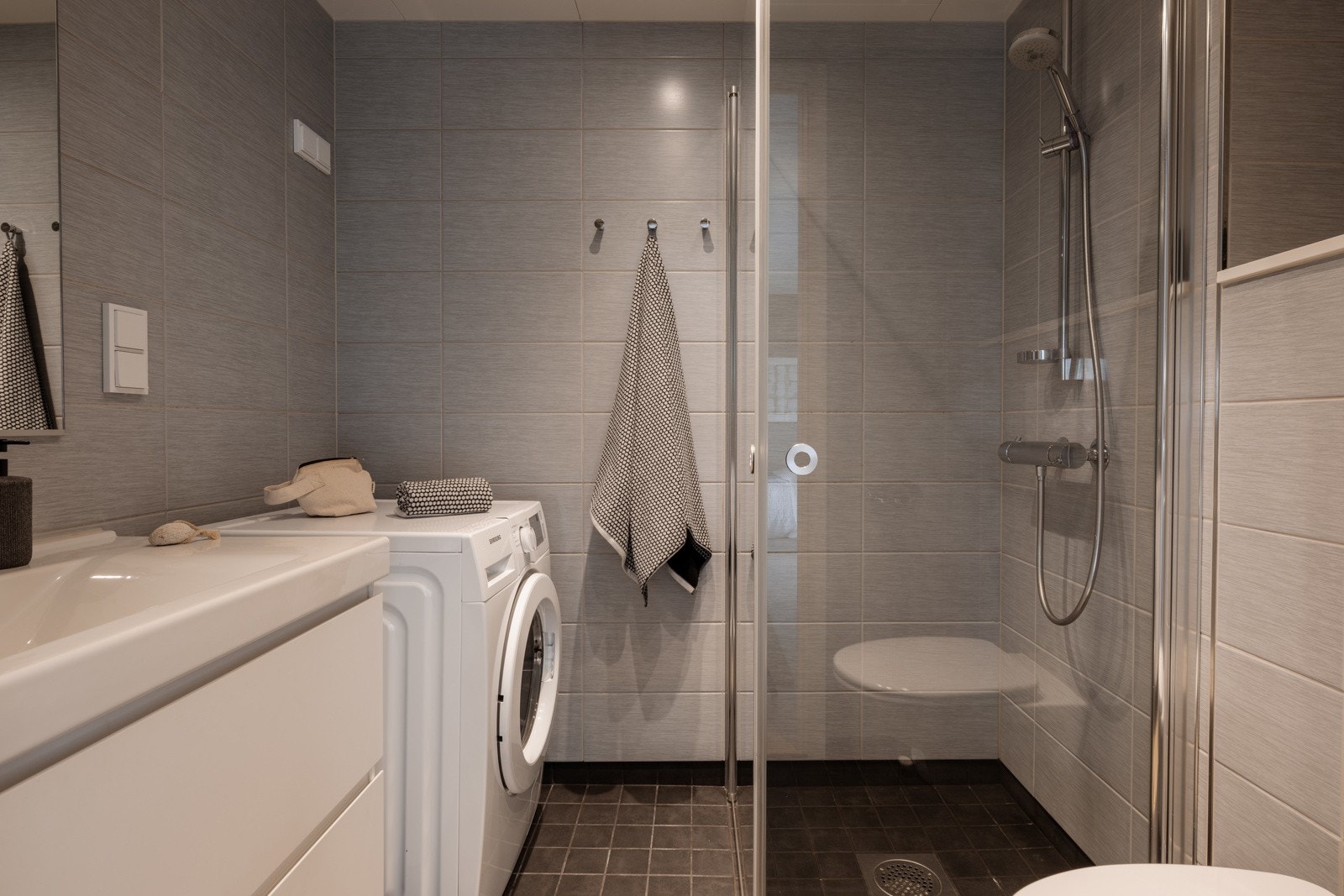 Badet er flislagt, har varme i gulvet og downlights i himlingen. Vaskemaskinen følger handelen. Galleribilde