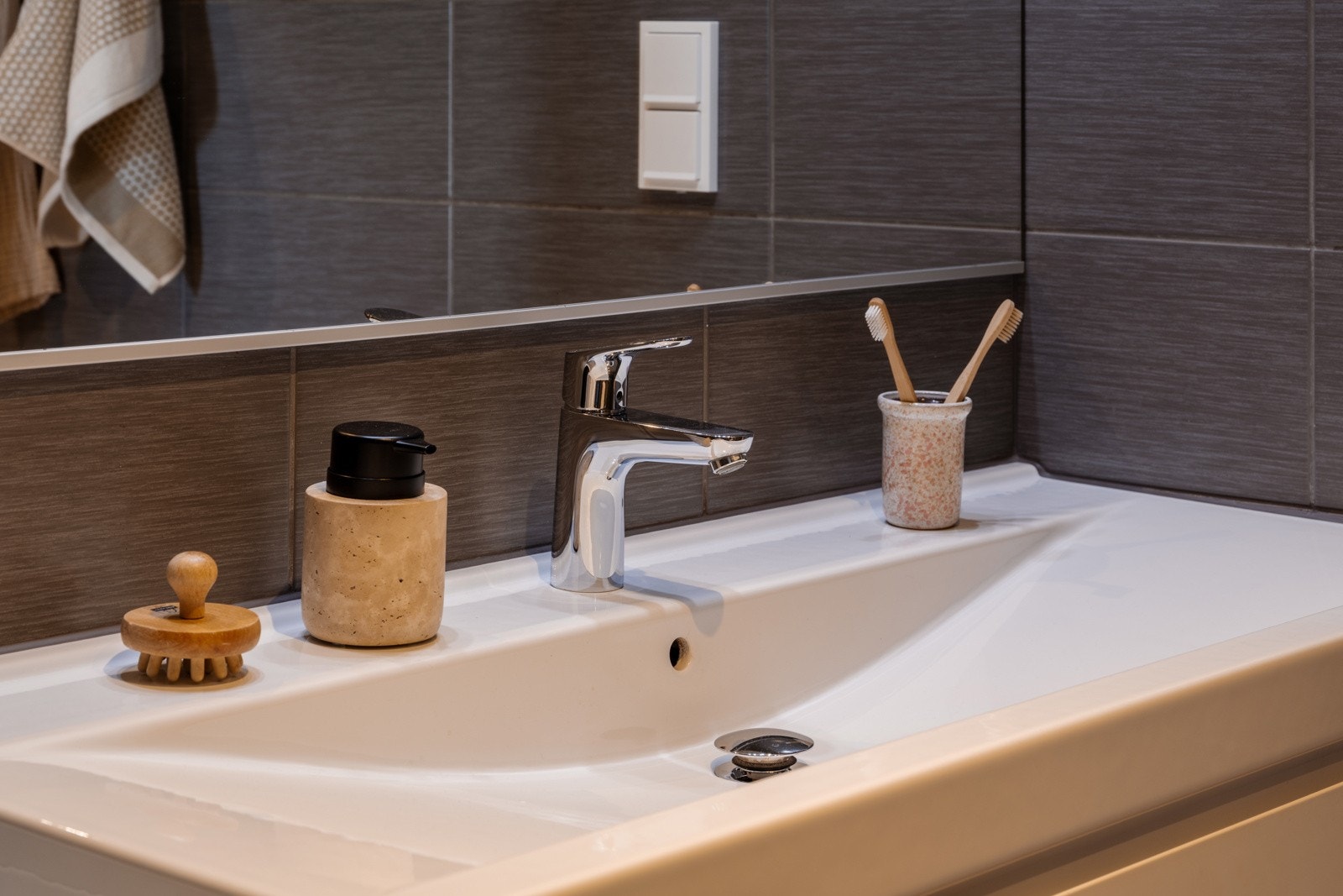 Badet er utstyrt med vegghengt servantinnredning med underskap, ovenpåliggende servant, speil med belysning, dusjhjørne og vegghengt toalett. Galleribilde