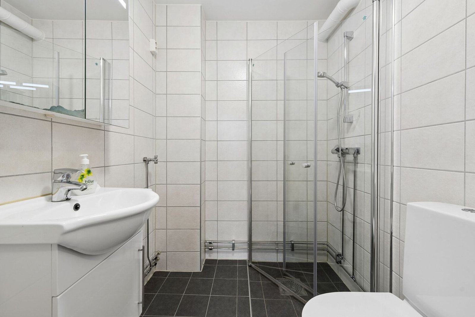 Flislagt baderom oppgradert i 2018 i regi av borettslaget, med gulvvarme som gir en behagelig lun temperatur. Galleribilde