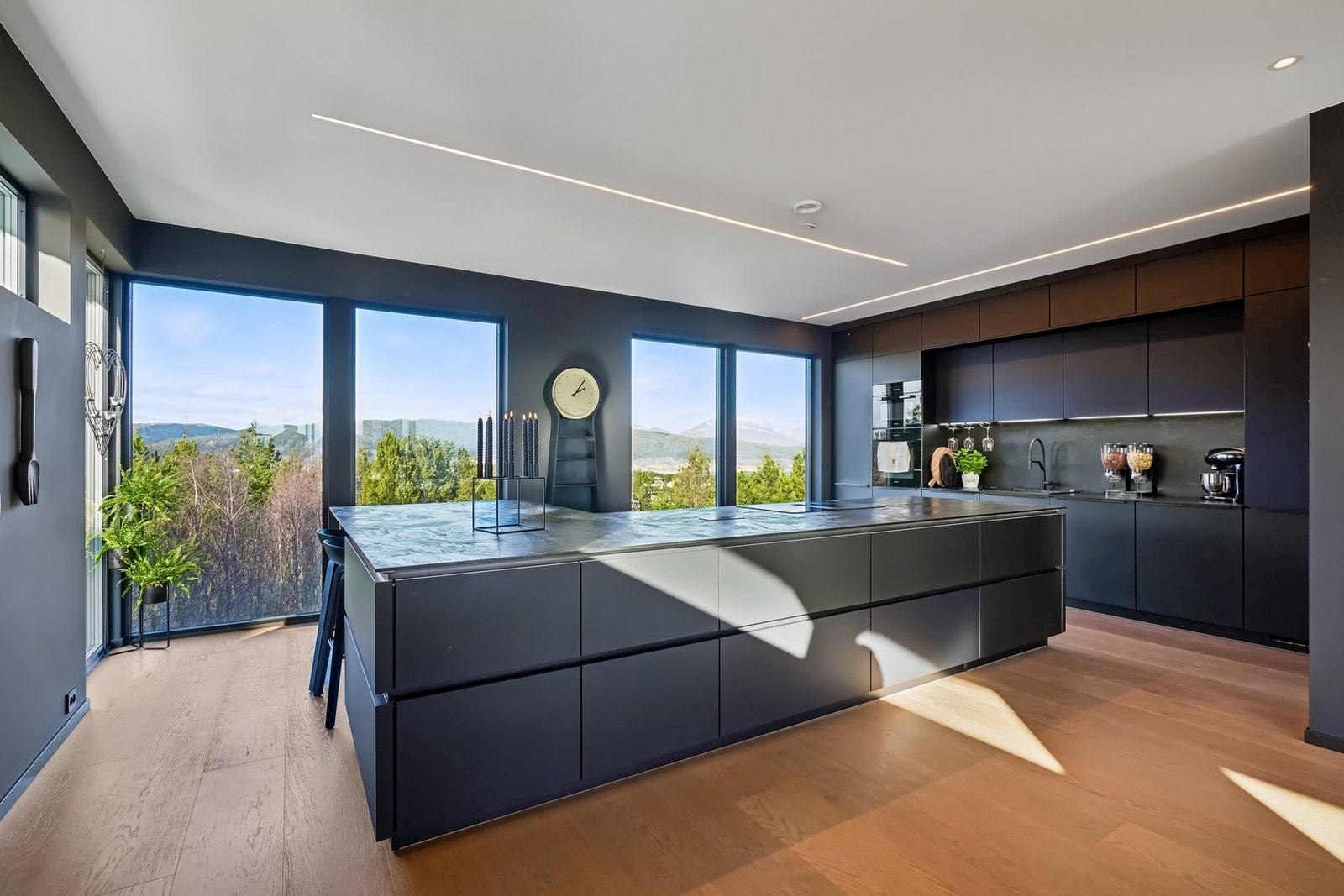 Meget lekker og velutstyrt kjøkkeninnredning med mørke glatte fronter og benkeplate. Galleribilde