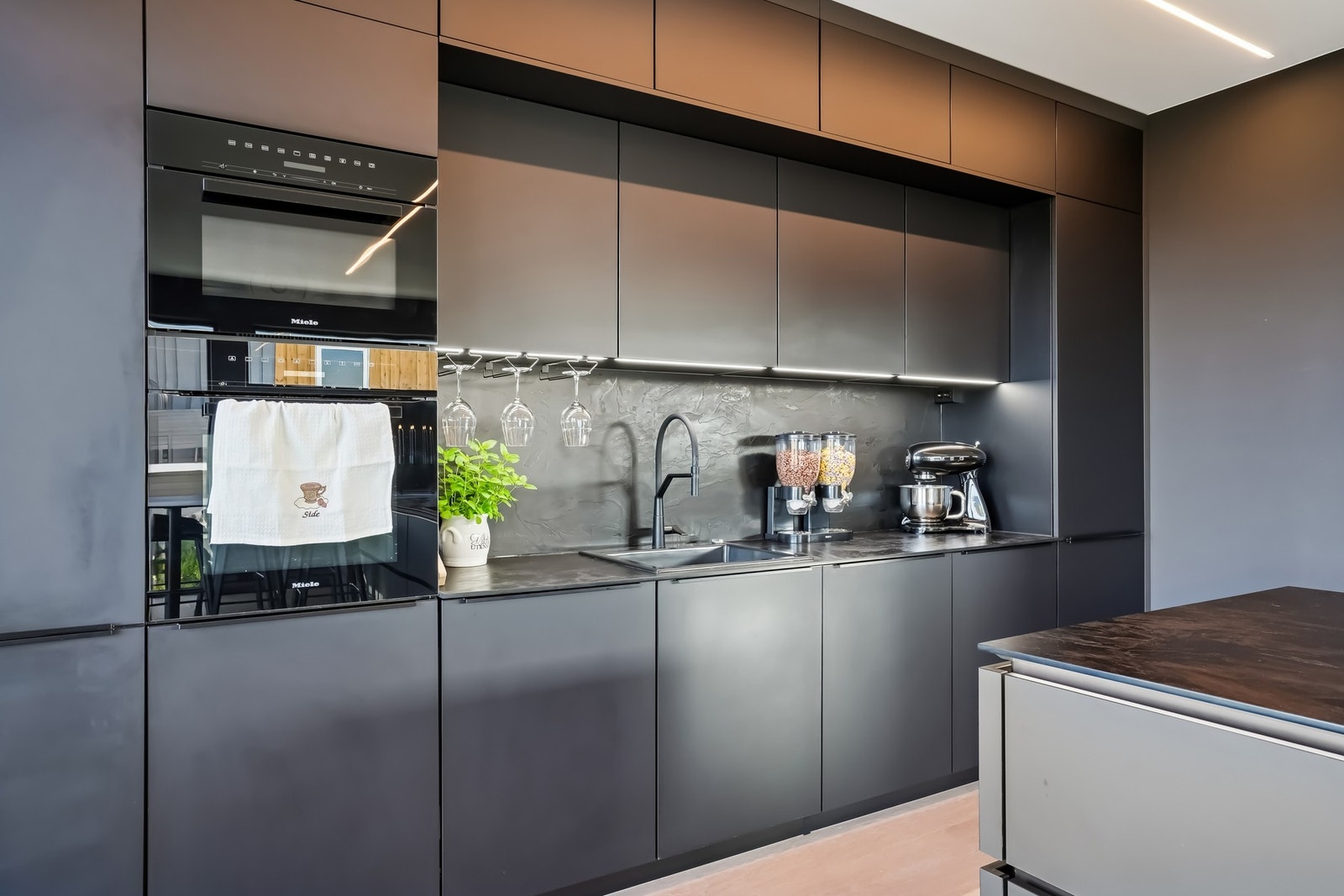 Integrerte hvitevarer som stekeovn, micro, oppvaskmaskin, induksjon platetopp, kjøleskap og fryseskap. Galleribilde