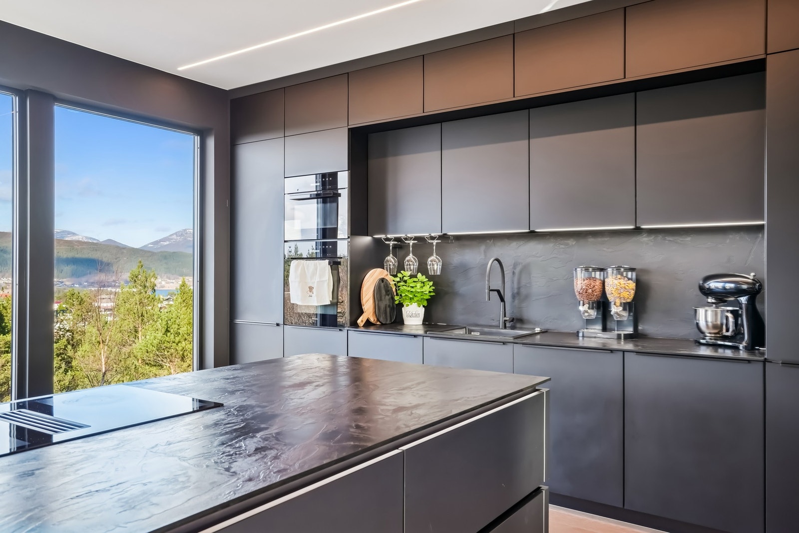 Ledstripene er gjennomgående på kjøkkenet. Praktisk el-søyle i benkeplaten. Galleribilde