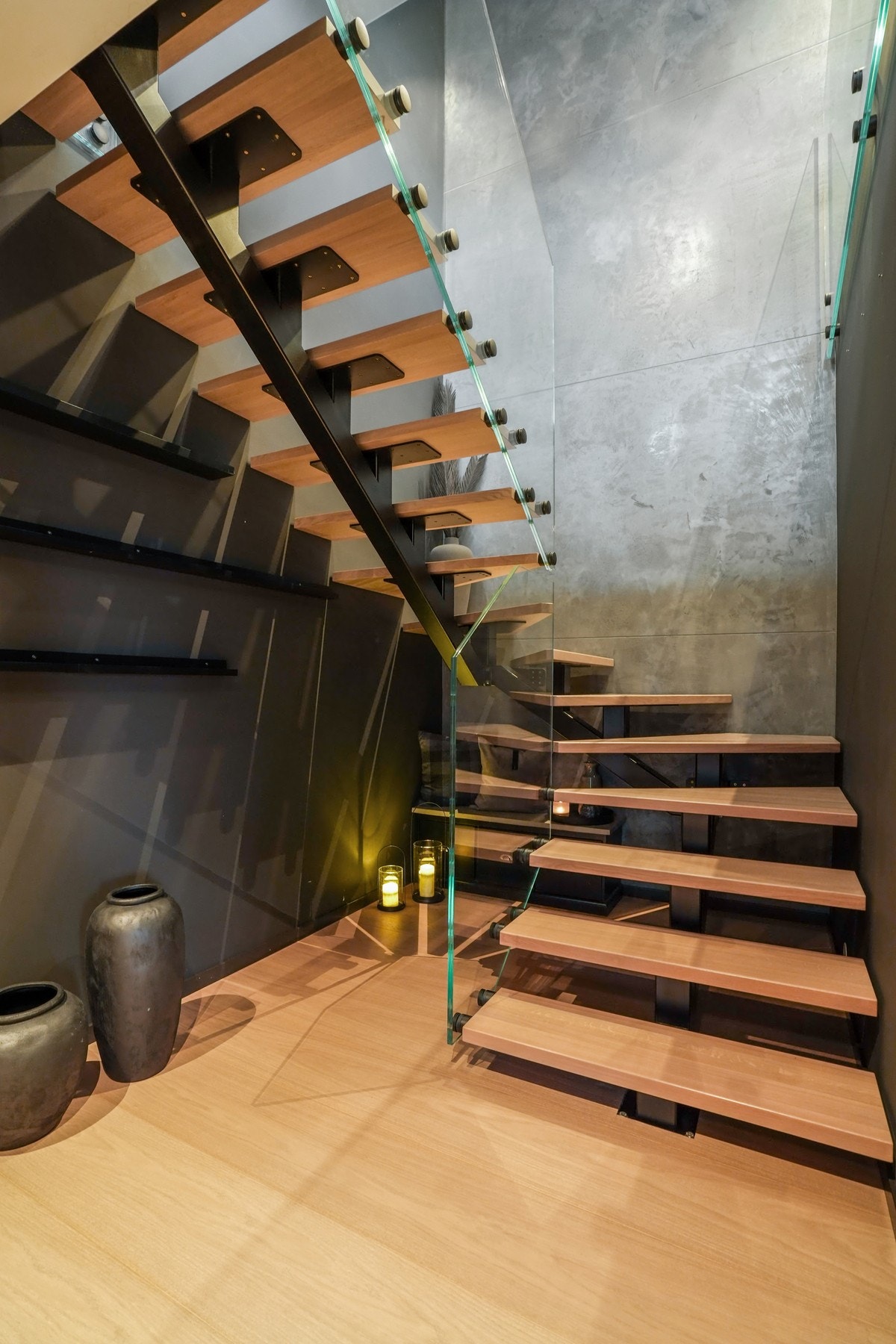 Vakker eiketrapp med diskret belysning og et elegant glassrekkverk som setter en eksklusiv tone til boligen. Galleribilde