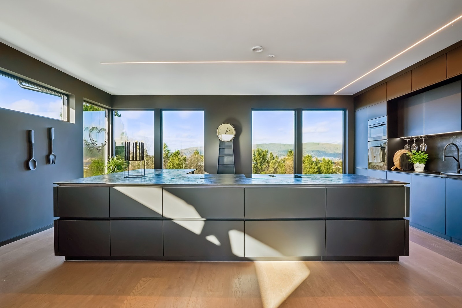 Husets naturlige samlingspunkt - en romslig kjøkkenøy omgitt av lys, utsikt og moderne detaljer. Galleribilde