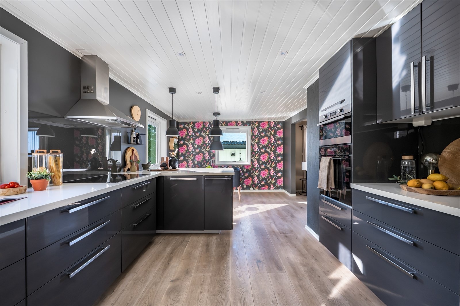 Moderne og tidsriktig kjøkkeninnredning som har godt med skap- og benkeplass. Det er laminert benkeplate og mørke glatte fronter. Galleribilde