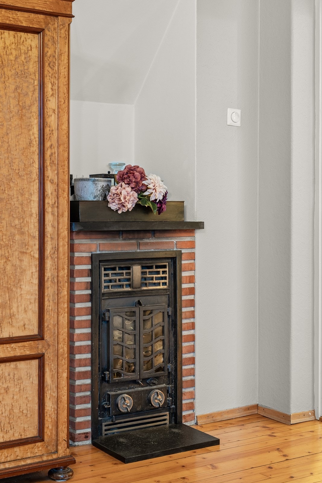 Den originale vedovnen i stuen tilfører rommet et særegent og koselig preg. I tillegg skaper den en lun og god varme i hele leiligheten. Galleribilde