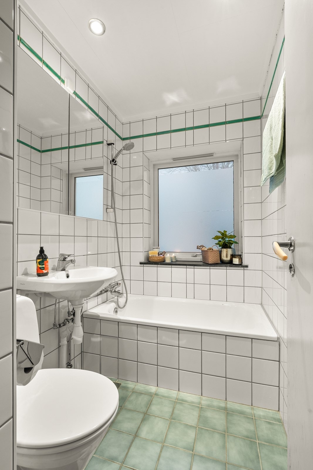 Flislagt baderom med elektrisk gulvvarme, badekar og downlights i himlingen. Galleribilde