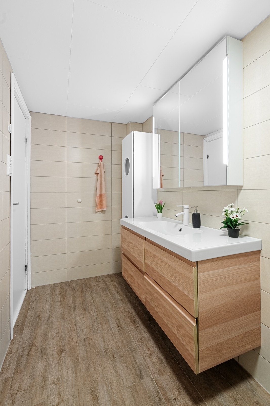 Flislagt bad med gulvvarme. Baderomsinnredning består av servant i seksjon med speil og overlys, oppbevaring under vask, toalett og dusjkabinett. Galleribilde