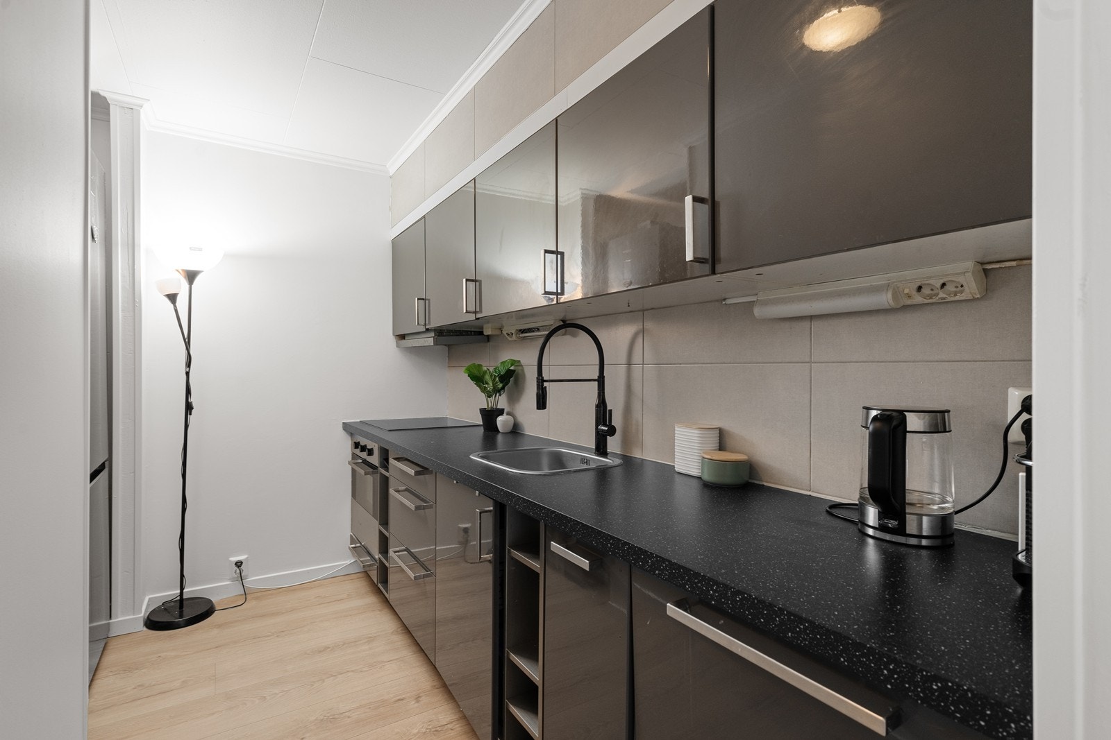 Flott kjøkkeninnredning med integrert koketopp, stekeovn, og oppvaskmaskin. Frittstående kjøleskap. Galleribilde