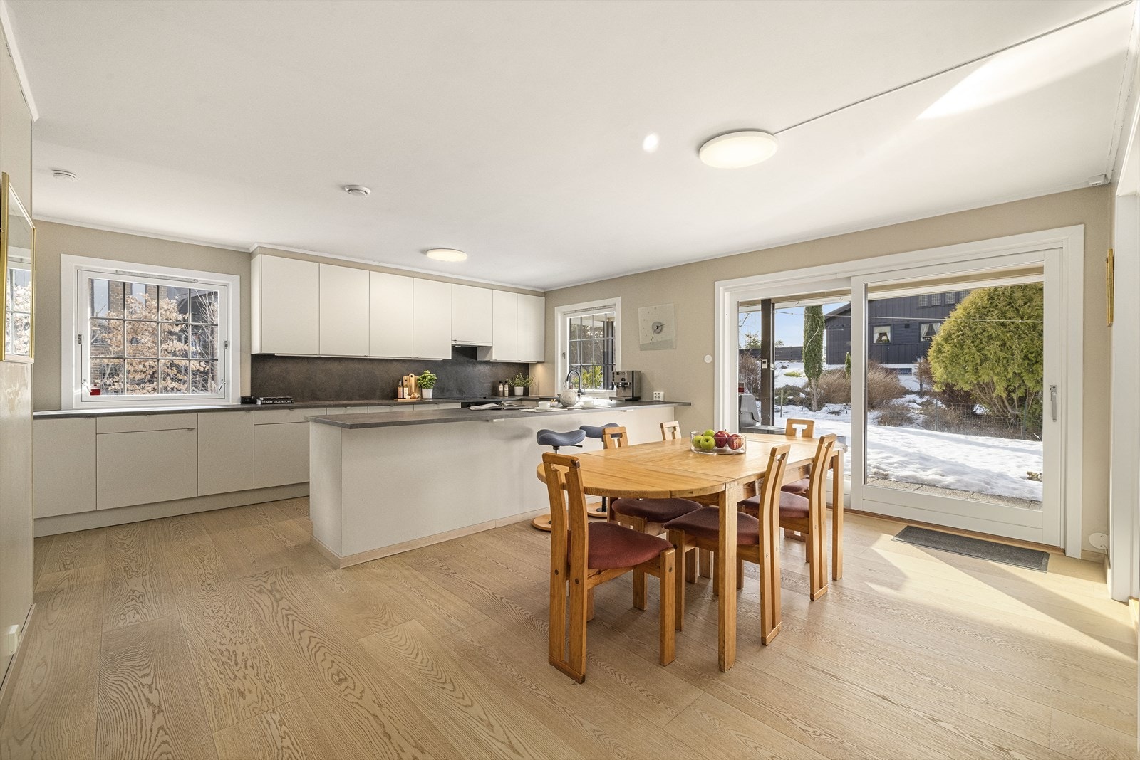 Kjøkkenet har stilren og moderne innredning, med lyse slette fronter og laminert benkeplate Galleribilde