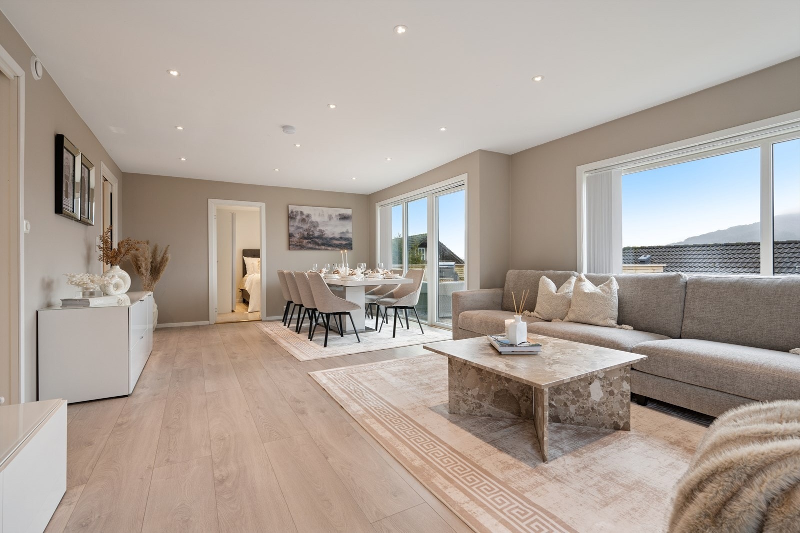 Boligen ble vesentlig modernisert i 2021. Her har man en lys og innbydende stue med store vindusflater og lysmalte veggflater i tidsriktige farger med listefrie overganger til tak. Galleribilde