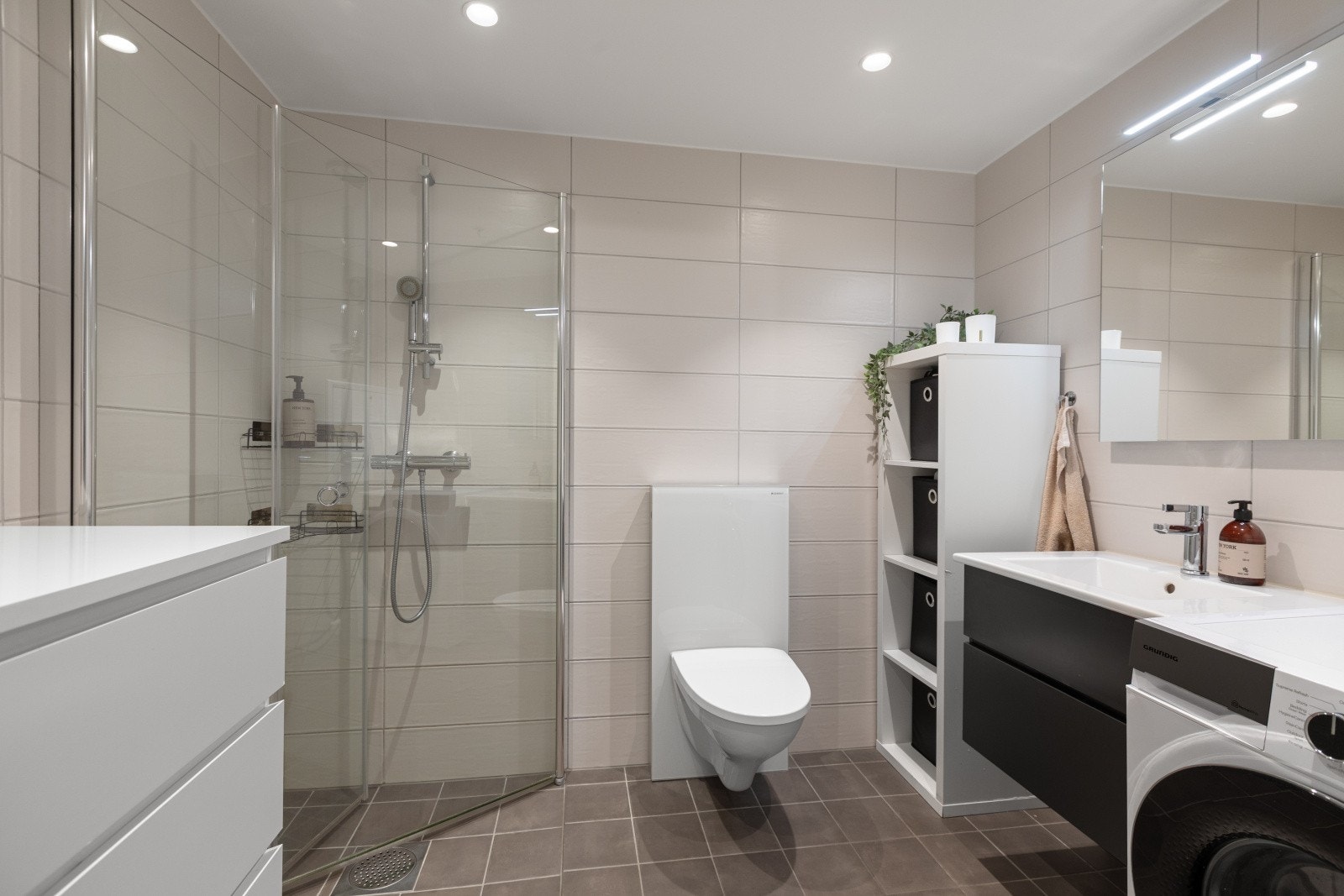 Flislagt og delikat baderom med vannbåren gulvvarme og downlights som skaper ekstra komfort og en behagelig atmosfære. Galleribilde