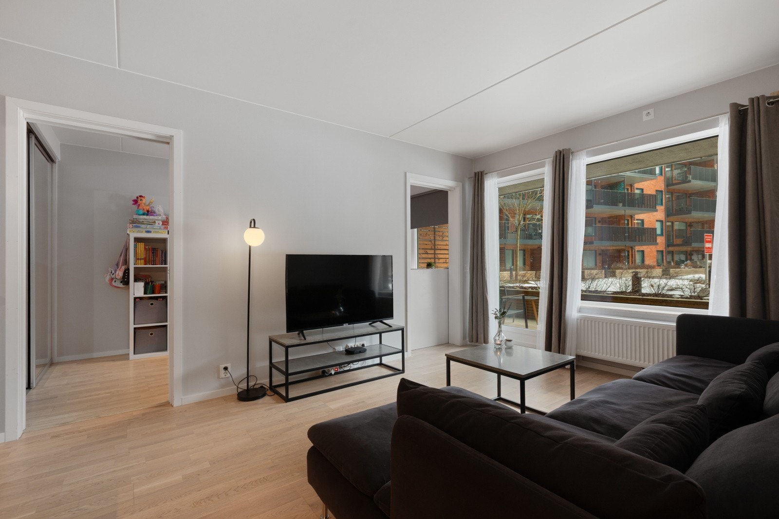 Store vindusflater slipper inn rikelig med dagslys, og rommet har god plass til både TV-hjørne, spiseplass og en komfortabel sofagruppe. Galleribilde