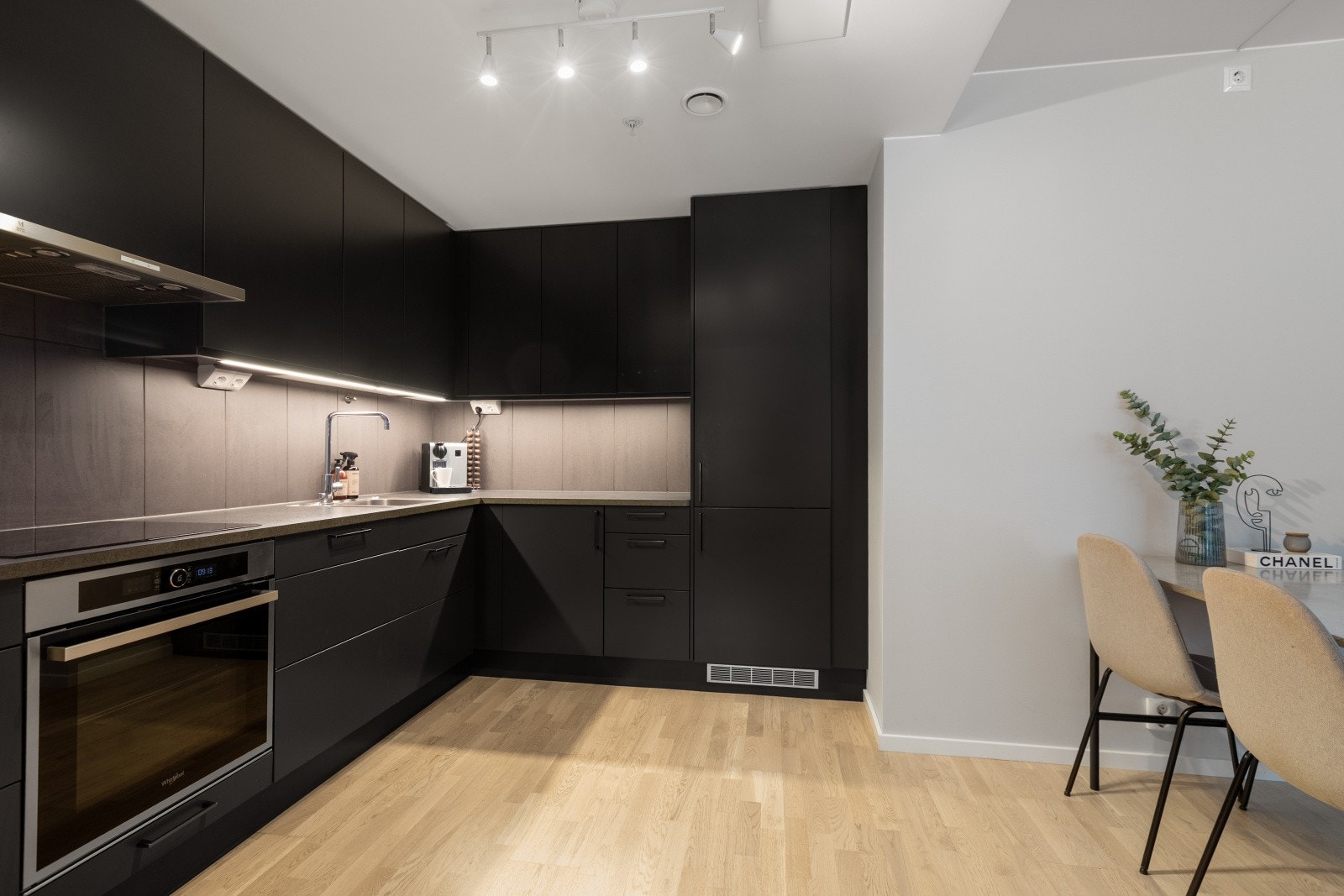 Kjøkkeninnredningen har glatte, moderne fronter som gir et ryddig og tidløst uttrykk, kombinert med en praktisk benkeplate i laminat. Galleribilde