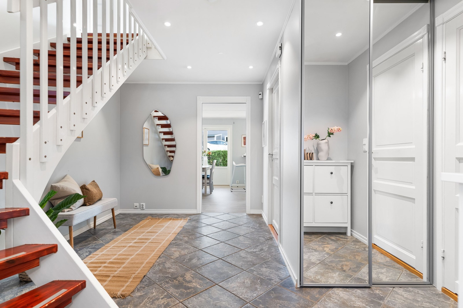 Flislagt entrè/gang med varme i gulvet. Her er det stor plass for oppheng av tøy og oppbevaring for øvrig. Skyvedørsgarderobe med speil. Galleribilde