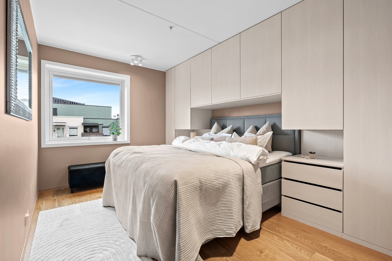 Lekkert hovedsoverom med spesialtilpasset garderobeinnredning og integrert nattbord Galleribilde