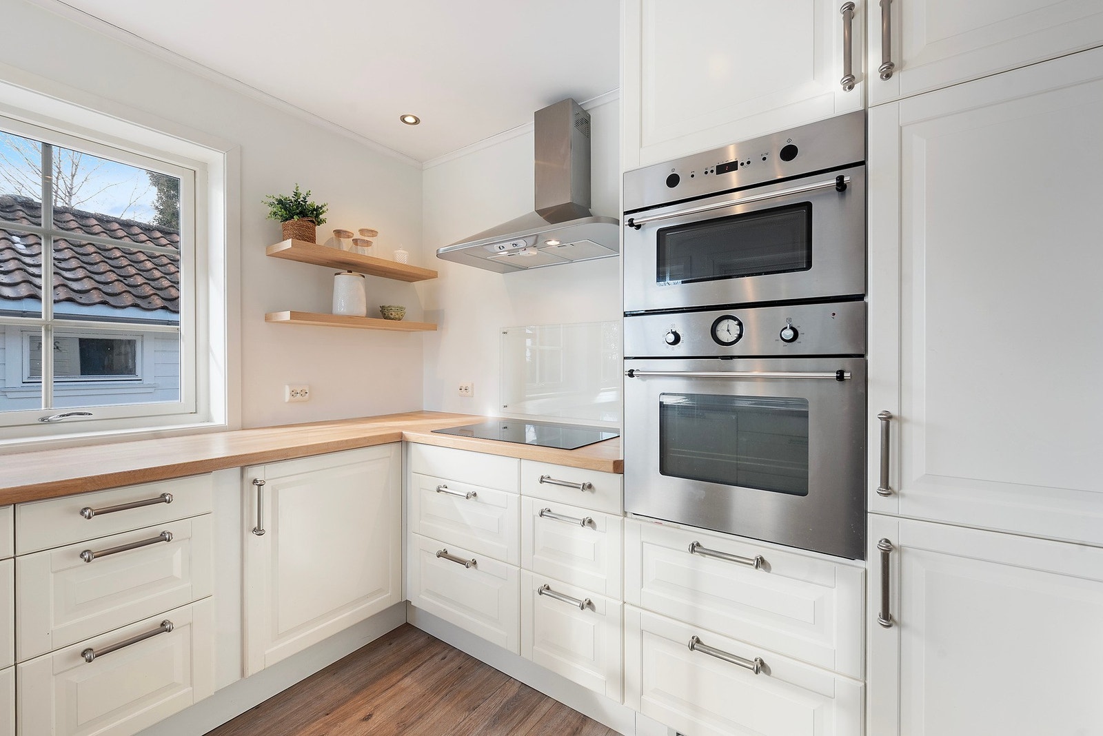 Et klassisk og tidløst kjøkken, kombinert med et moderne uttrykk gjennom integrerte hvitevarer og godt arbeidslys fra downlights Galleribilde