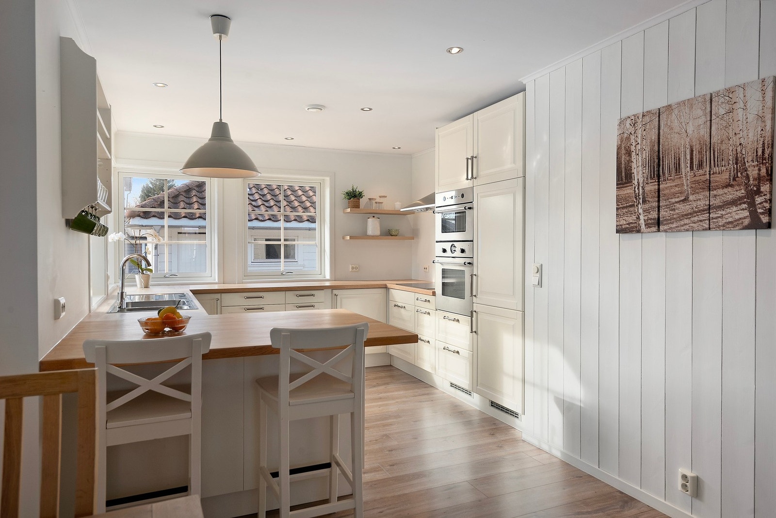 Elegant kjøkkeninnredning som harmonerer fint med malt panel på veggene Galleribilde