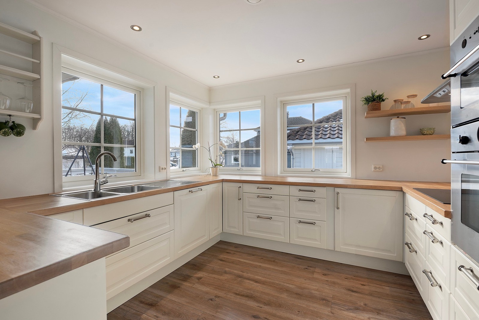 De store vindusflatene langs ytterveggen bidrar med å åpne kjøkkenet Galleribilde