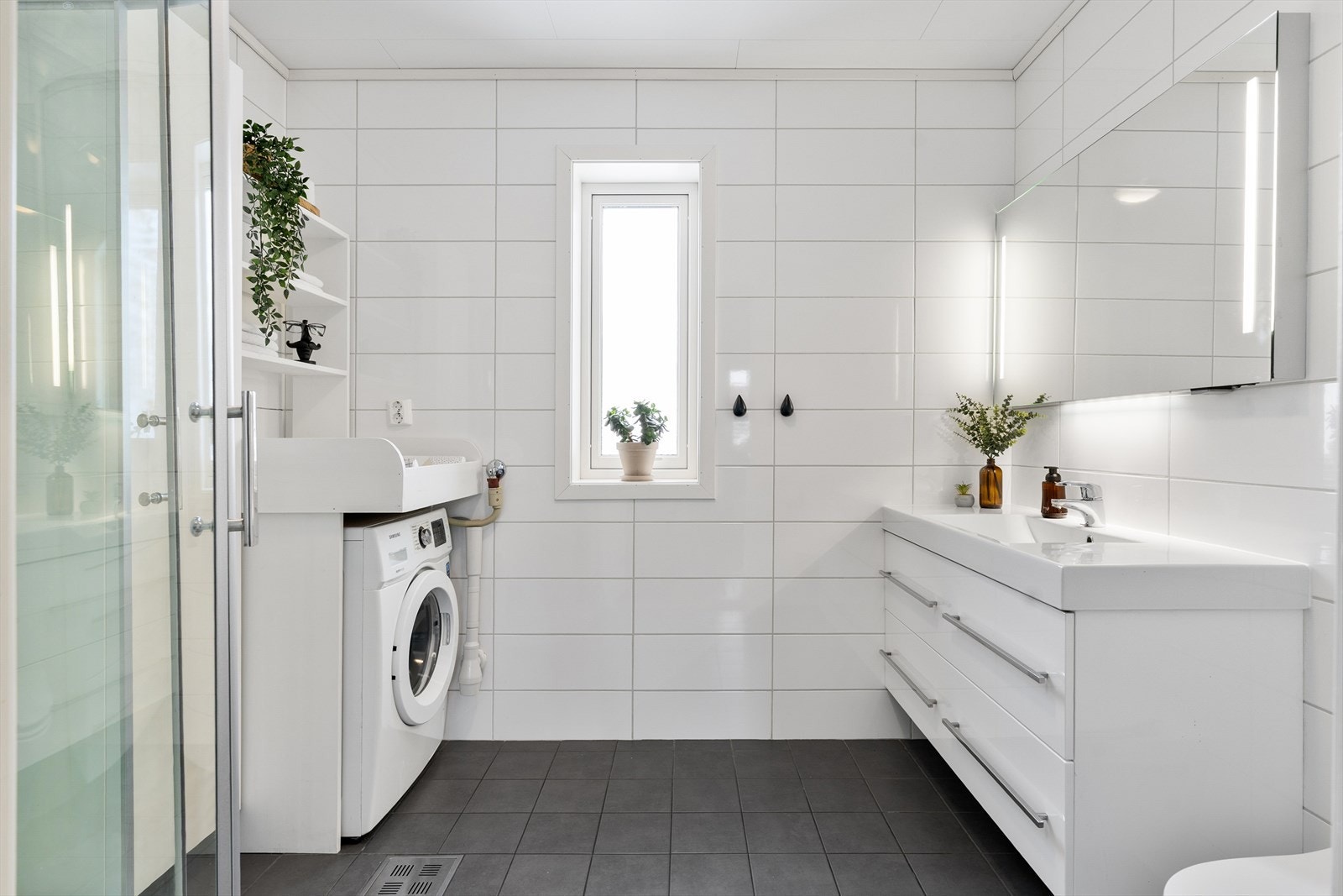 I 1. etasje finner man boligens bad, som er flislagt og med behagelig varme i gulv. Ekstra romslig servantskap gir godt med plass til oppbevaring for baderomsartiklene. Galleribilde