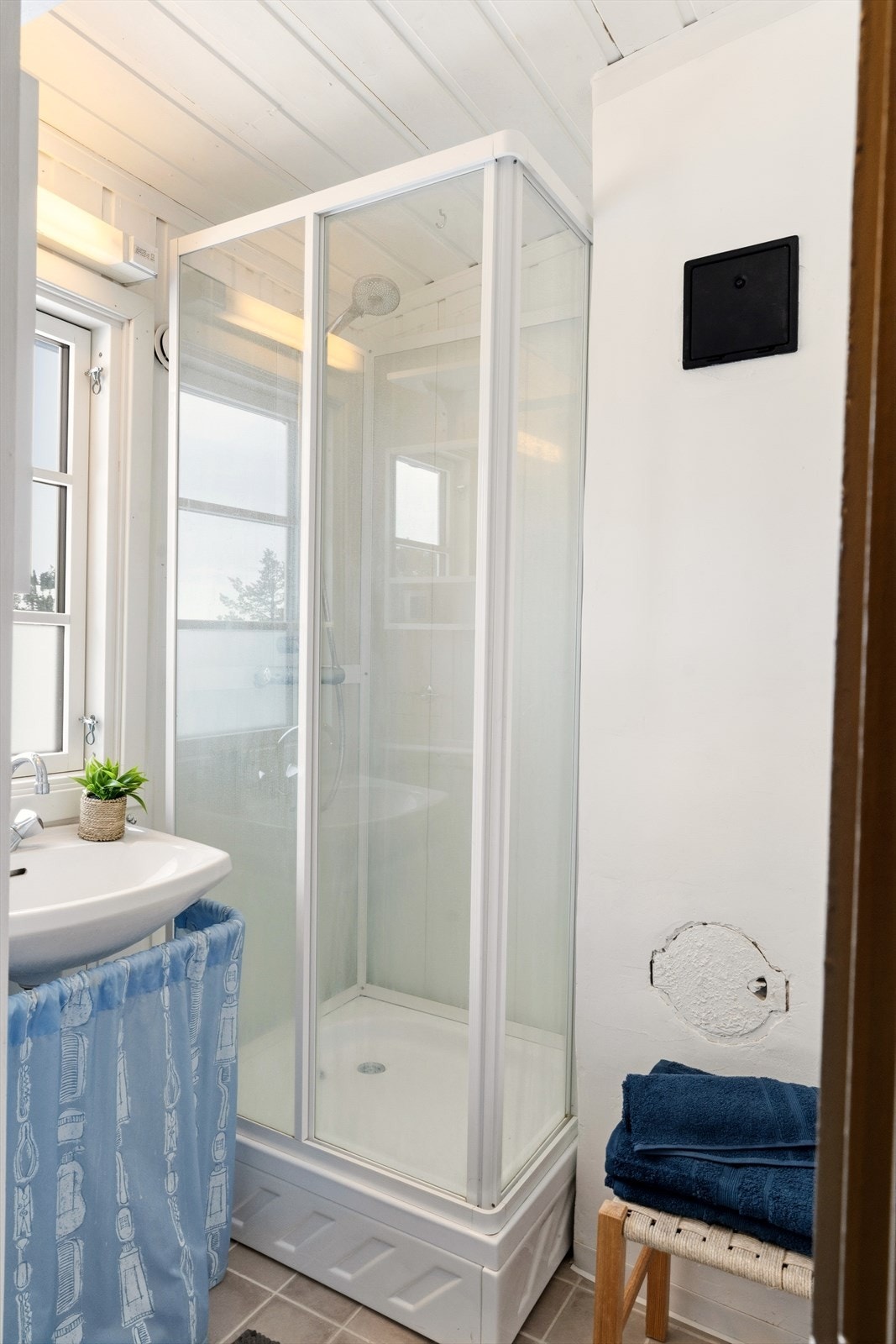 Baderommet har flislagt gulv med varmekabler, samt dusjkabinett og servant. Galleribilde