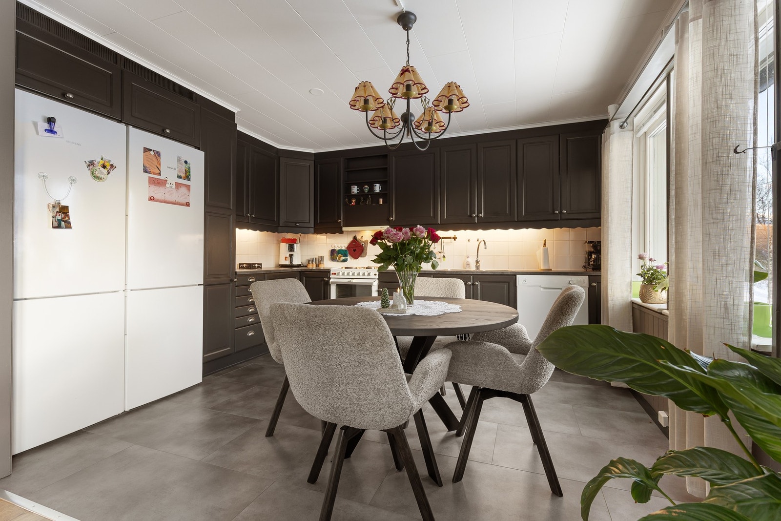 Kjøkkenet har en funksjonell utforming med dobbel stålvask, fliser på vegg over benk og opplegg for oppvaskmaskin. Galleribilde