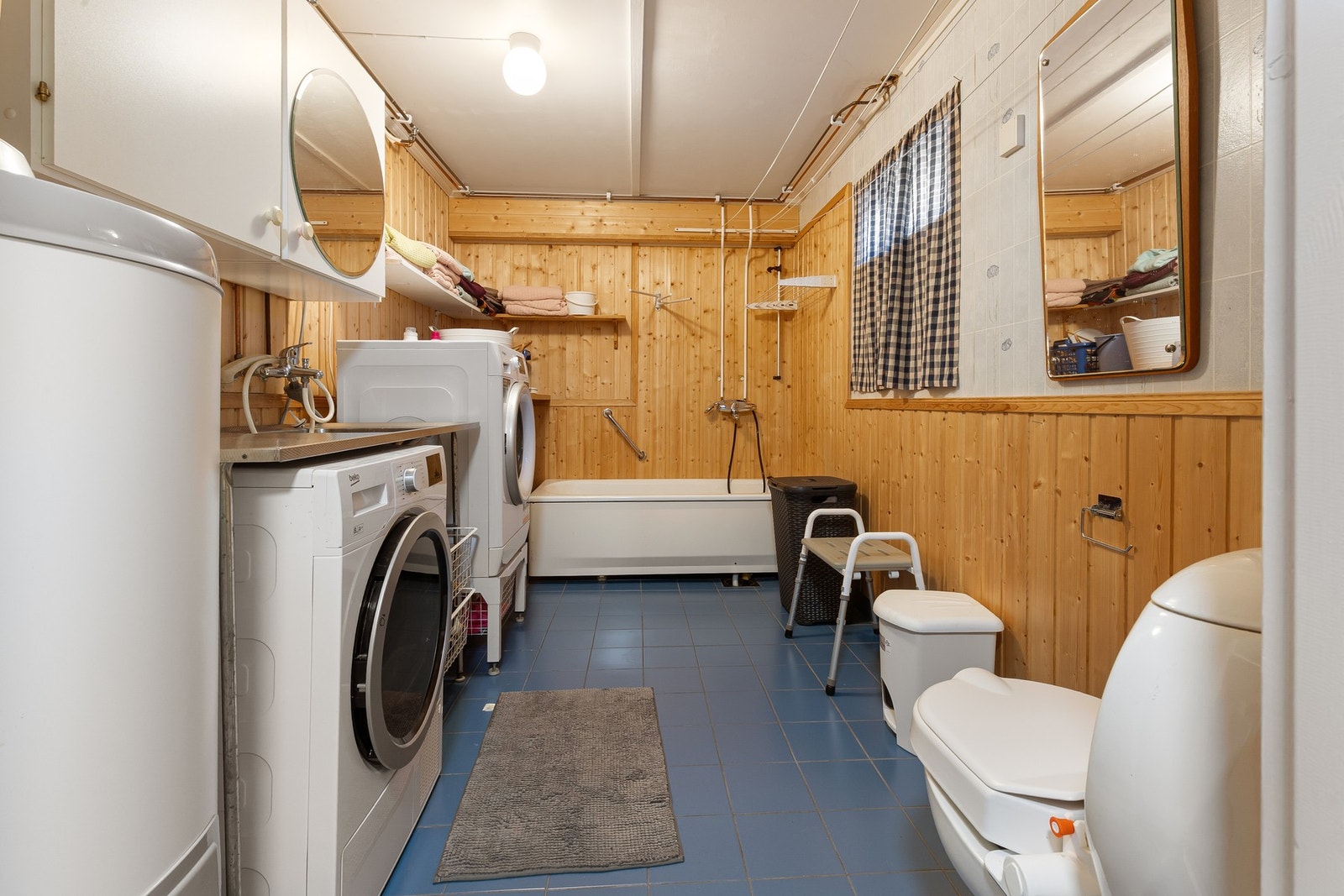 Vaskerommet fremstår som romslig og praktisk, med plass til både vaskemaskin, tørketrommel og arbeidsflate. Galleribilde